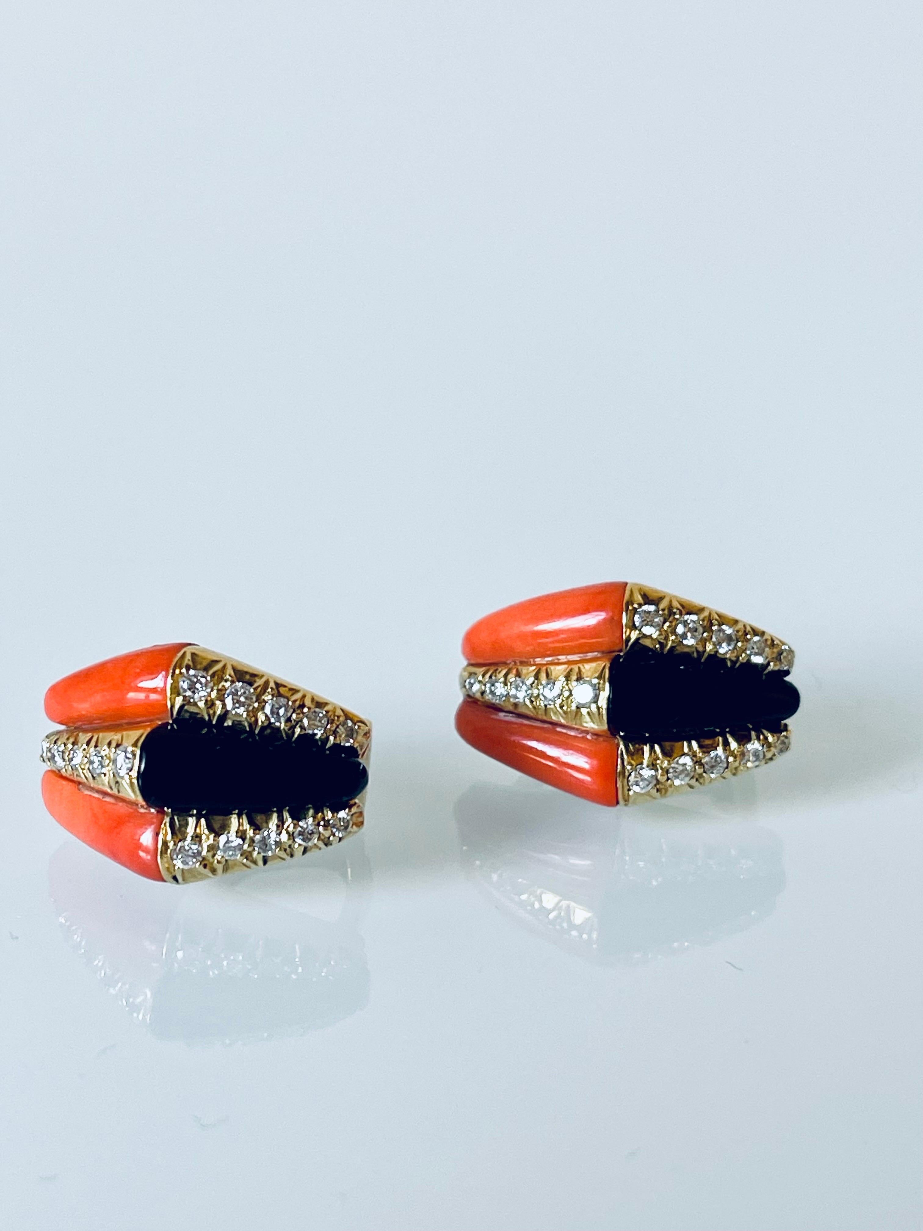 A rare pair of vintage earrings by Tiffany & Co, crafted in solid 18K YG and featuring custom cut polished natural medium salmon color coral and black onyx stones adorned with fine quality diamond accents. The geometric design of these earrings
