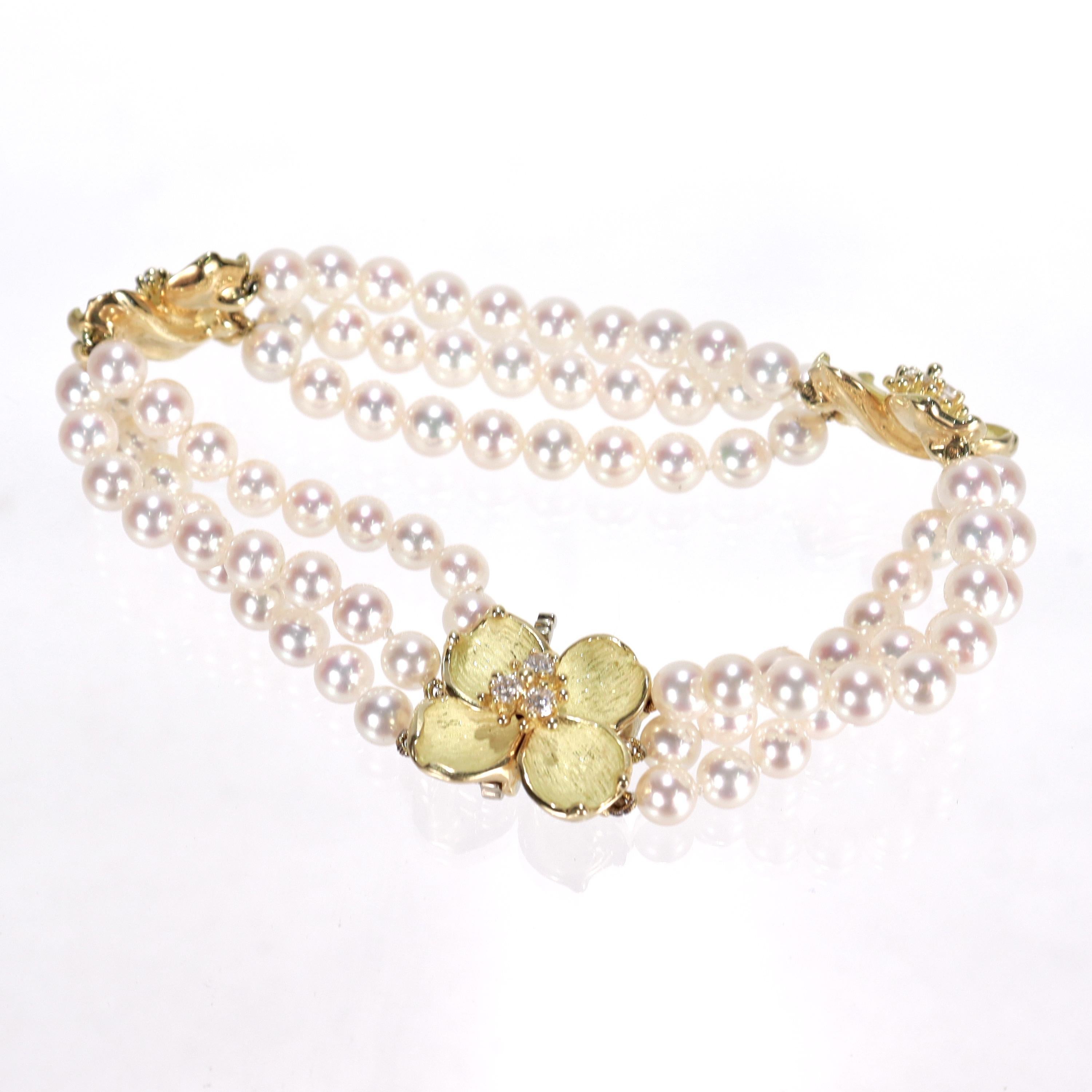 A very fine gold, diamond and pearl 'Dogwood' bracelet. 

By Tiffany & Co. 

In 18k yellow gold.

With three strands of 4.5-5mm cultured pearls, two sculpted gold dogwood blossoms centered on a round cut diamond cluster pistil, and a conforming