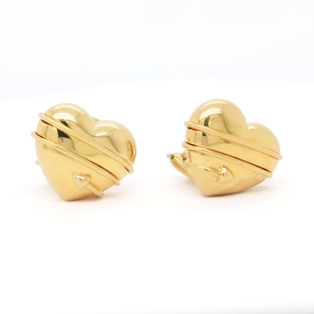 A fine pair of Tiffany & Co. clip earrings.

In 18 karat gold.

In the Cupid Arrow pattern - in the shape of a heart wrapped with an arrow. 

Marked to the reverse Copyright 1994 / Tiffany & Co. / 750.

Simply wonderful Tiffany