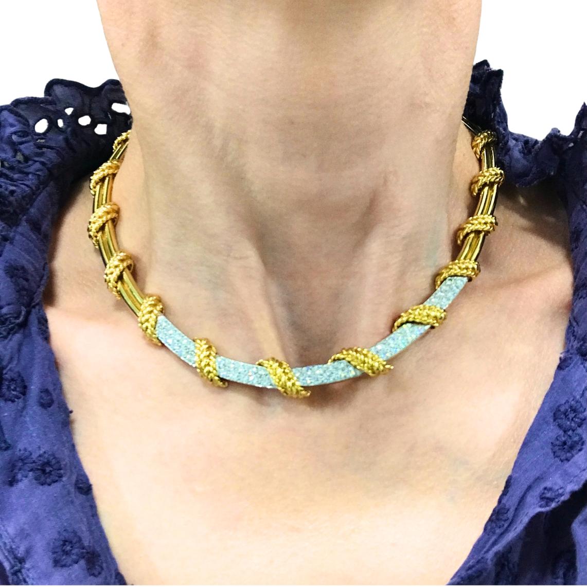 Questa collana vintage di Tiffany & Co. è realizzata in oro 18 e presenta diamanti.
La collana è disegnata con un elegante motivo a corda che crea una silhouette fluida intorno alla scollatura.
Il pezzo presenta un'alternanza di maglie in corda