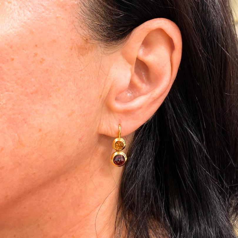 Questi squisiti orecchini a goccia di Tiffany & Co,  realizzato in  Oro giallo 18k. Ogni orecchino presenta un vibrante citrino rotondo incastonato sopra un granato rotondo dalle tonalità ricche, creando un contrasto sorprendente di toni caldi e