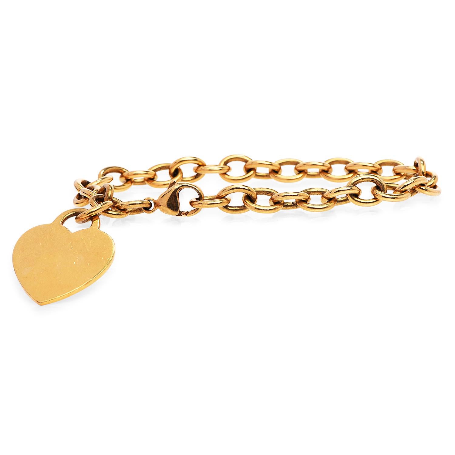 This Tiffany & Co. Dog Tag Link Bracelet is a multifunctional piece for a timeless look.

Crafted in solid 18K yellow gold, It has rolo style highly y polished links. accented by a Heart shape charm, stamped