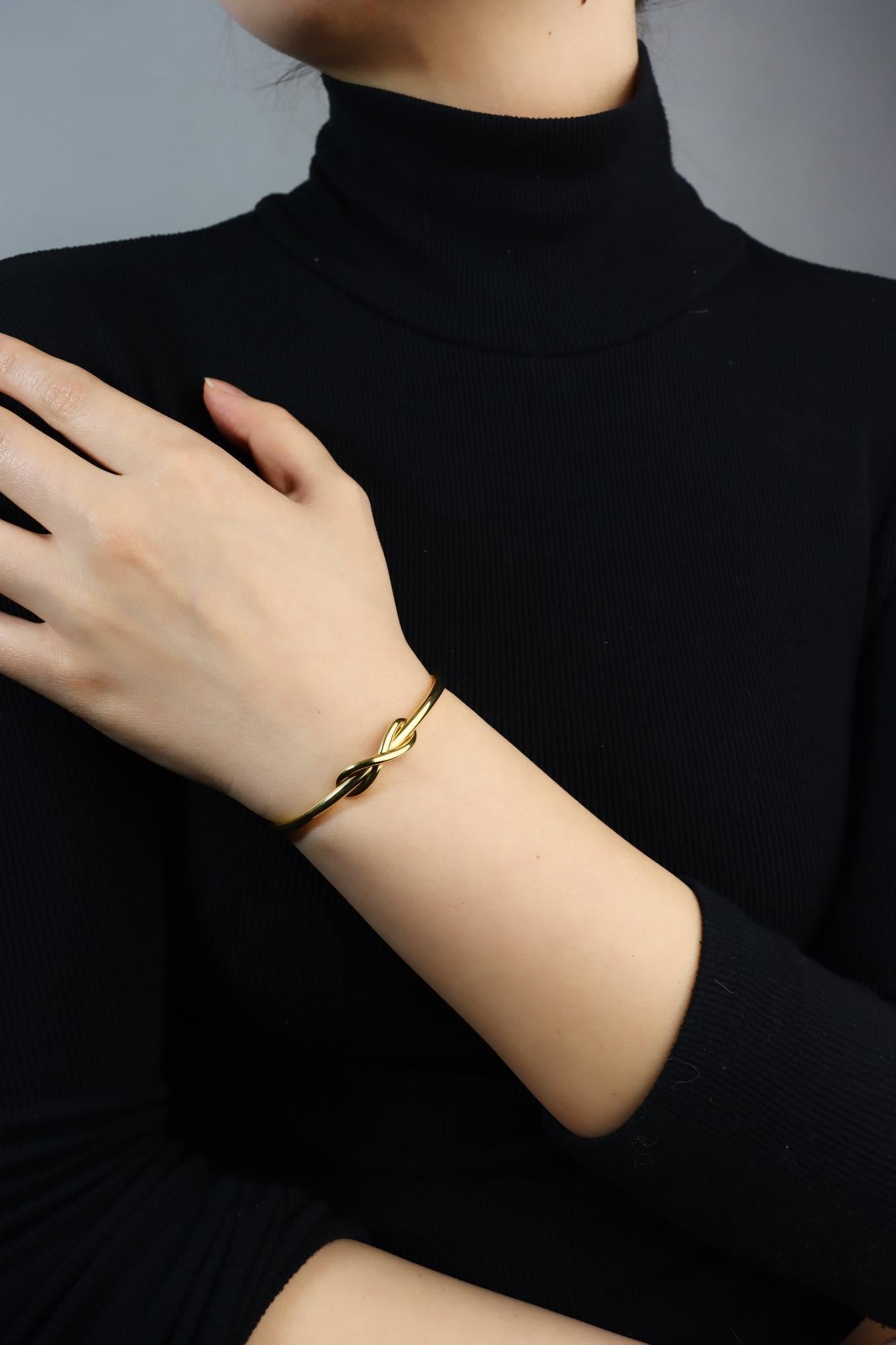 Tiffany & Co. 18K Gold Infinity Cuff Bracelet

Marked:
Tiffany & Co. 
Au 750

Approximate Dimensions:
12 cm (Length) 
0.8 cm (Width)
17.0 grams in weight.