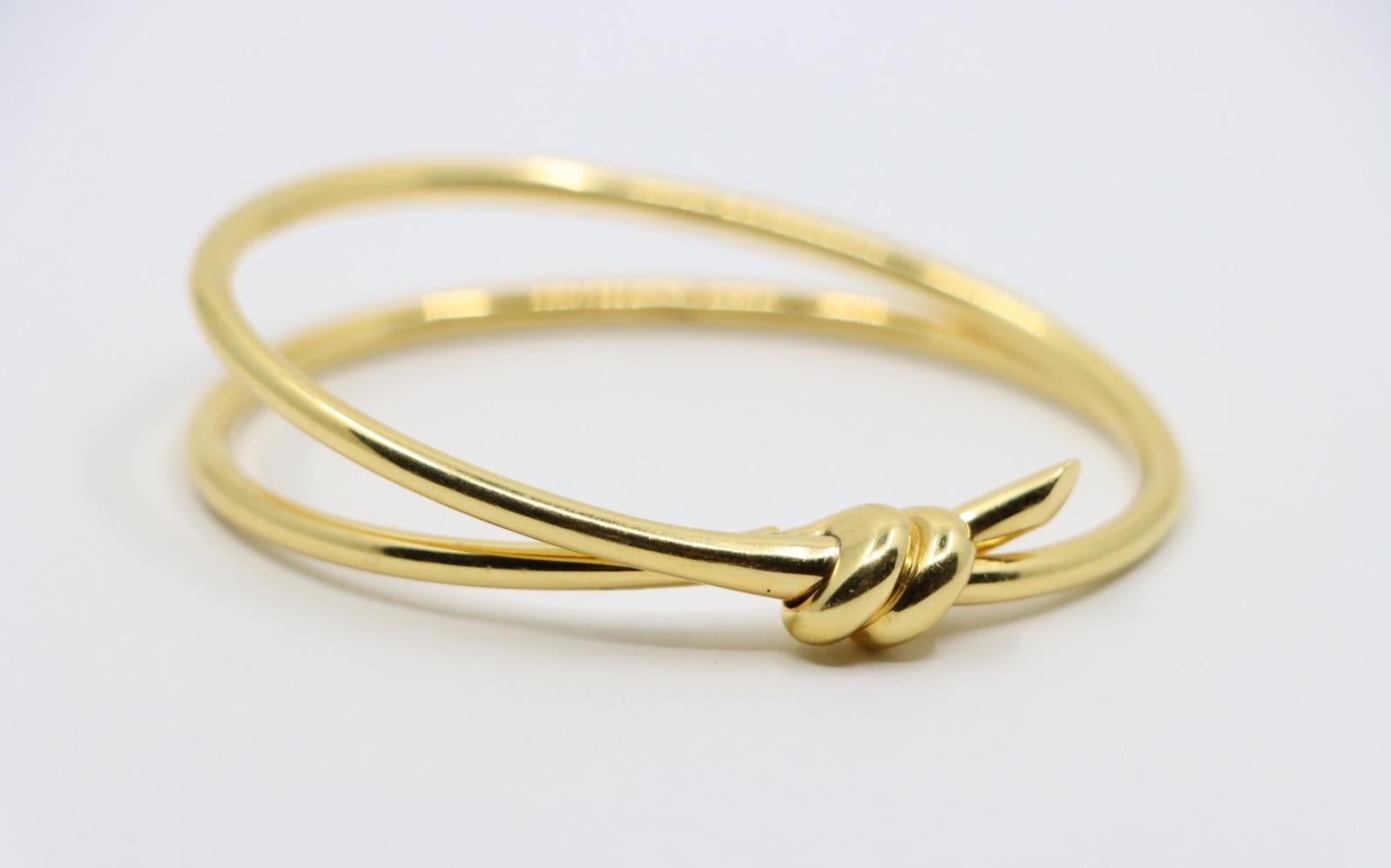 Tiffany & Co. 18K Gold Knot Double Row Hinged Bangle
Marked:
TIFFANY & Co.
Au 750 ITALY

Approximate Dimensions:
16.5 cm ( Length) 
1- 1.4 cm (Width) 
40.6 grams in weight.