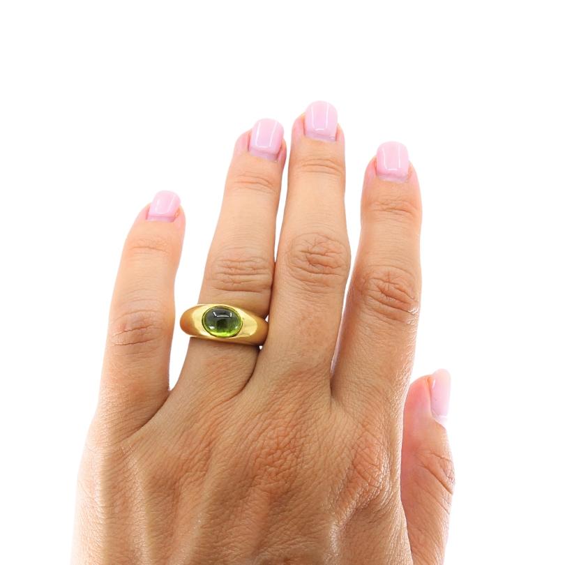 
A classic band ring by Tiffany & Co., featuring an oval cabochon-cut peridot bezel-set in 18K yellow gold. The ring has a smooth, rounded profile with a polished finish, designed in Tiffany’s signature sleek and timeless style.
Stamped with Tiffany