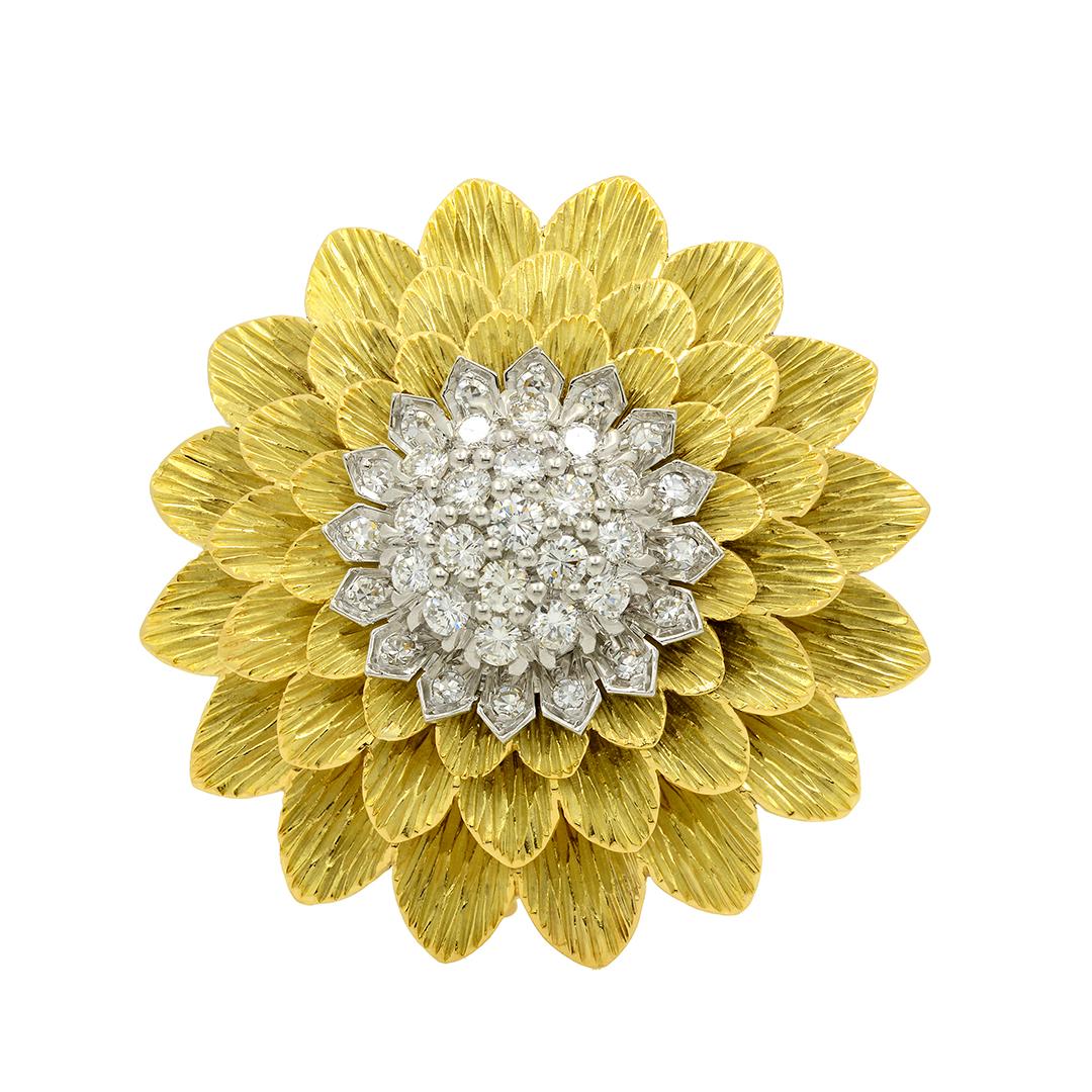 From Tiffany & Co, this 18 karat yellow gold and platinum sunflower brooch features a cluster of 19 round brilliant cut diamonds weighing an approximate combined total of 1.00 carats and 16 single cut diamonds weighing an approximate combined total