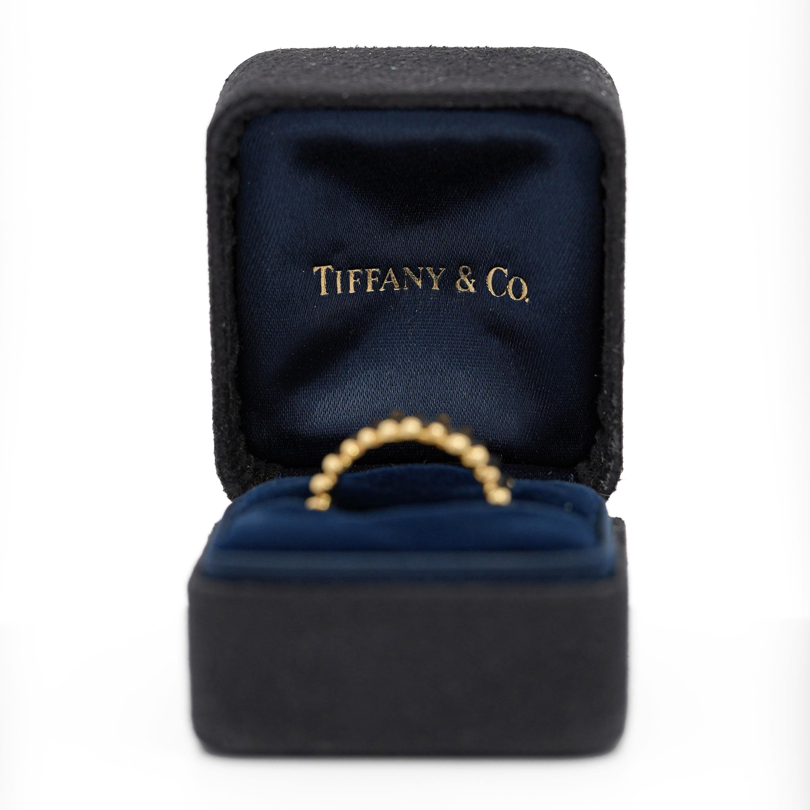 Stunning 18K yellow gold ribbed band ring, created and designed by Tiffany & Co. With a 12mm width, this beautiful band features a distinct ribbed texture that adds dimension and style. Sometimes referred as a stick ring. Its an edgy design with