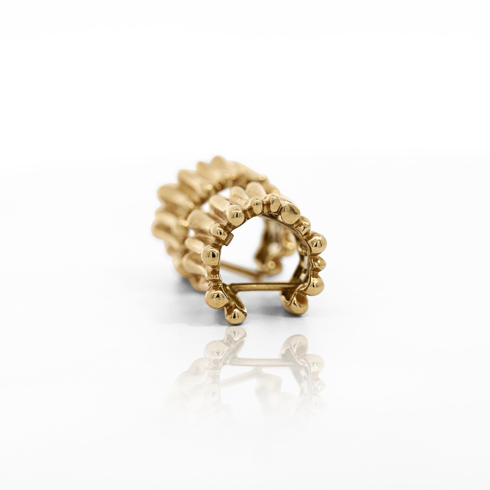 18K ribbed gold huggie earrings from Tiffany & Co. Crafted from high-quality 18K yellow gold, these earrings feature a unique ribbed stick design that brings a modern twist to a traditional piece. With a width of 11.5mm and a total weight of 10