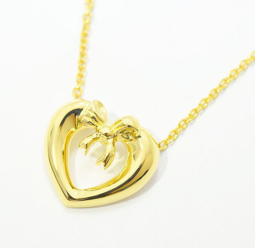 TIFFANY & Co. Collier avec pendentif en or jaune 18 carats en forme de ruban et de cœur

Métal : Or jaune 18K
Chaîne : 16
