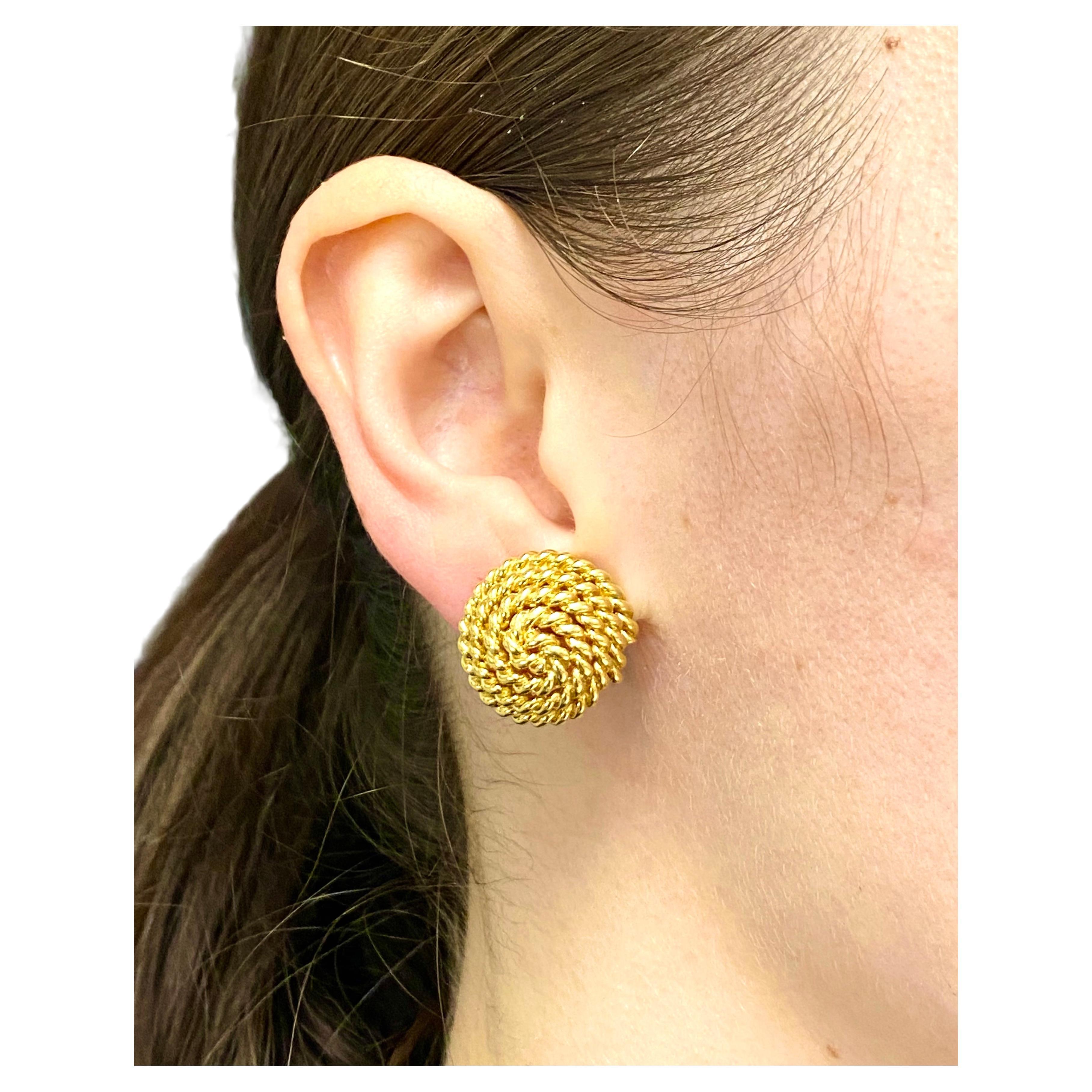 A pair of rope earrings by Tiffany & Co. made in 18k gold. The earrings have a convex shape,
with a gold rope being staged as a swirl. The gold is polished and braided which makes the
earrings look shiny and glossy. The round shape is a reference to