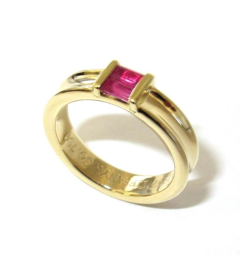  TIFFANY & Co. 18K Gold Ruby Stacking Ring 4.5

Metal: 18K yellow gold
Size: 4.5
Band Width: 4.5mm
Ruby: two emerald cut rubies, carat total weight .30
Hallmark: ©1997 TIFFANY&Co. 750 
Condition: New, never worn, comes with Tiffany pouch and