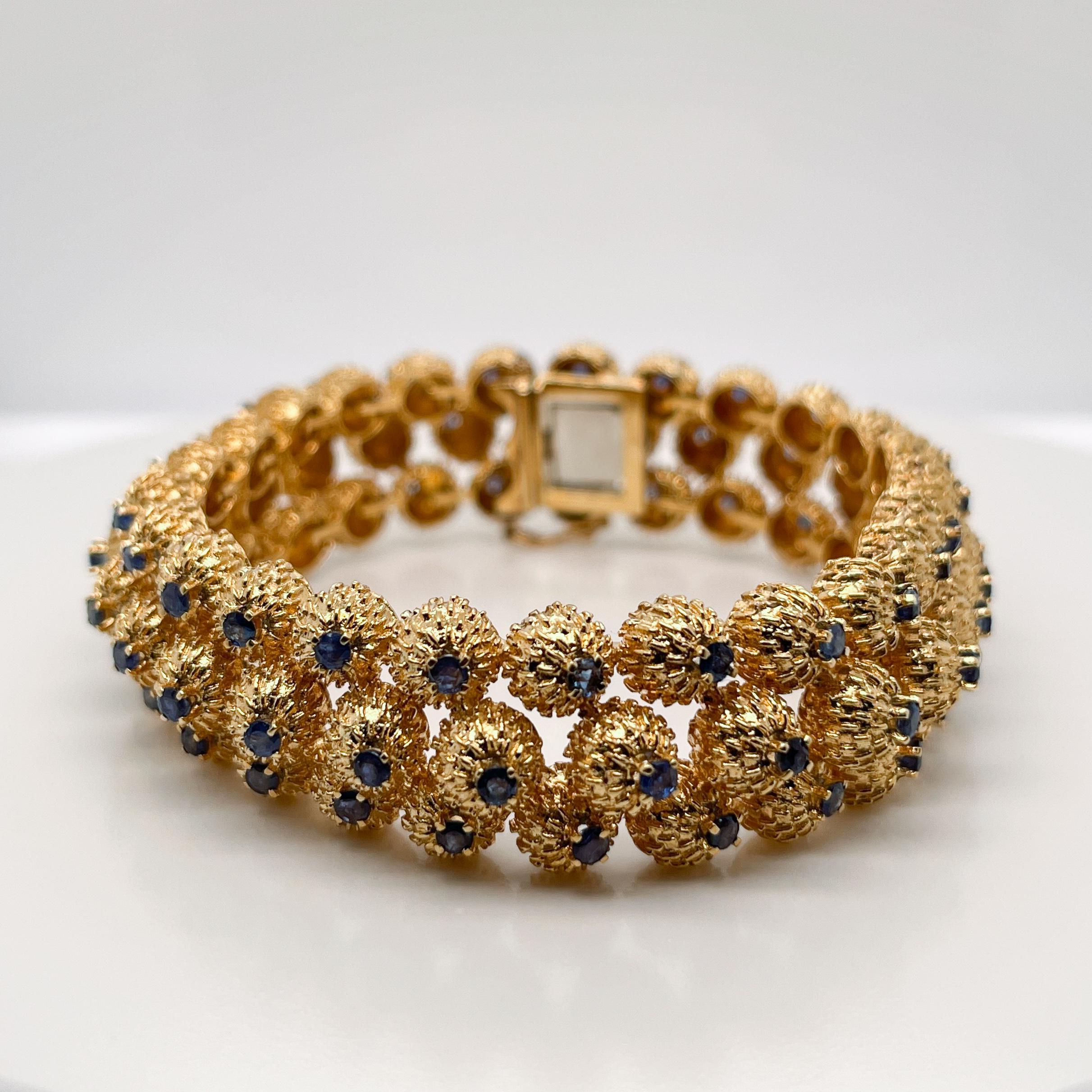A fine gold and sapphire bracelet. 

By Tiffany & Co. 

With three rows of stylized thistle bud links prong set with round cut sapphires.

In the style of Jean Schlumberger.

Simply great Tiffany design!

Date:
20th Century

Overall Condition:
It is