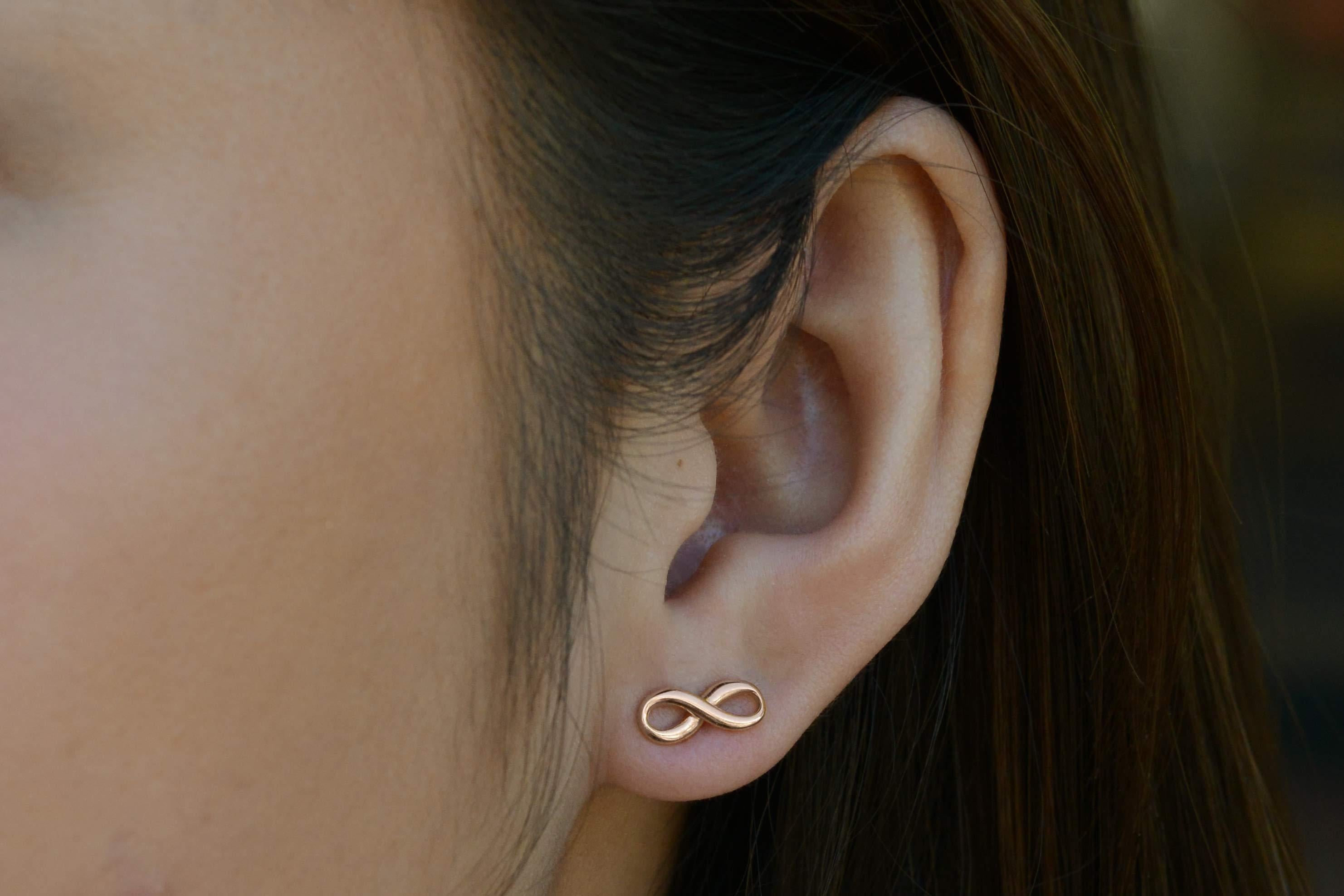 A darling pair of Tiffany & Co. Infinity studs. These earrings are finely crafted out of 18k rose gold with a lovely blush patina. Can be worn horizontally or vertically, this design is retired and is no longer available in Tiffany boutiques. See