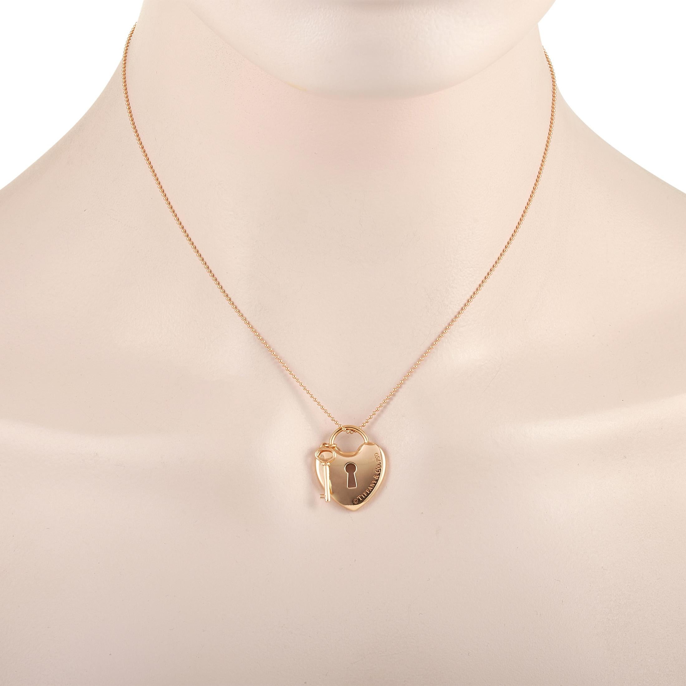 This cute Tiffany & Co. 18K Rose Gold Lock and Key Heart Pendant Necklace is made with an 18K rose gold chain and features a rose gold padlock-shaped pendant and matching key. The padlock is engraved with the Tiffany & Co. brand name. The dainty 18K