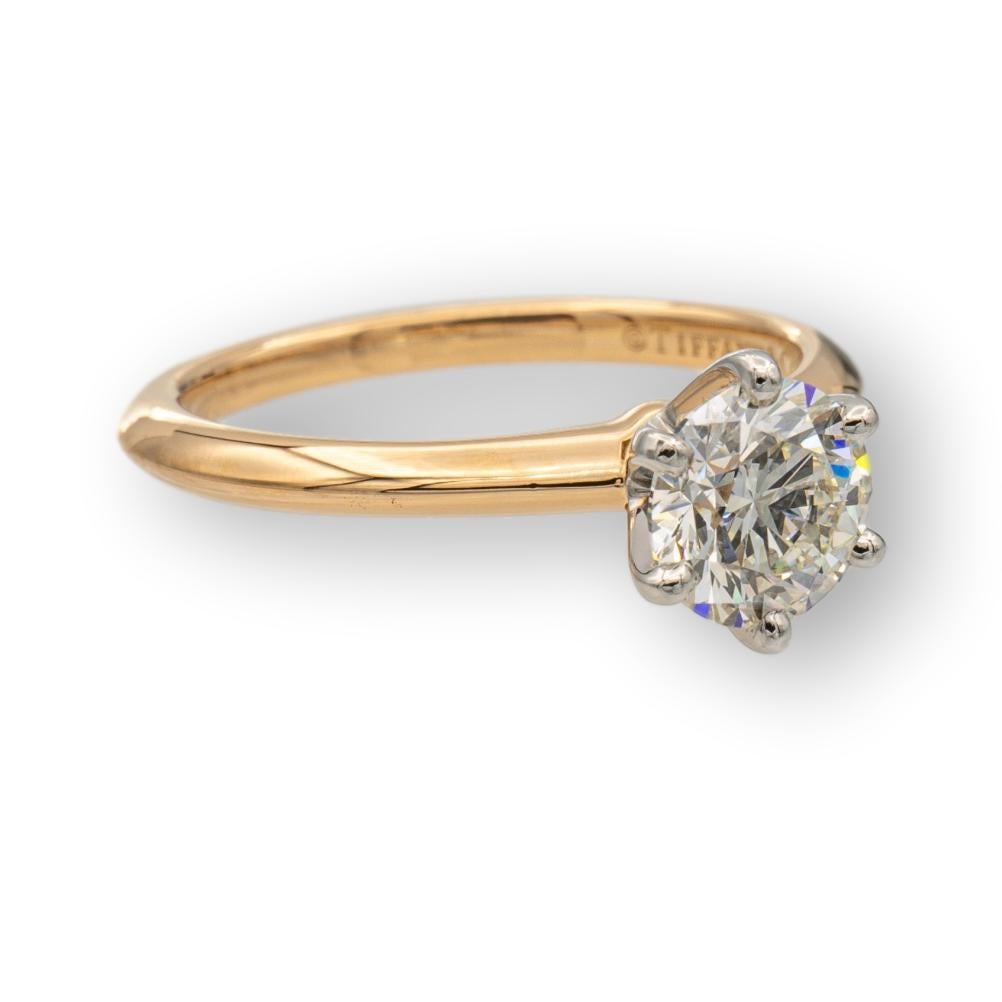 Tiffany and Co. solitaire engagement ring finely crafted in 18 Karat rose gold featuring a round brilliant 1.01 carat diamond center I color , SI1 clarity set in a platinum 6 prong basket setting. The ring is accompanied by a certificate and receipt