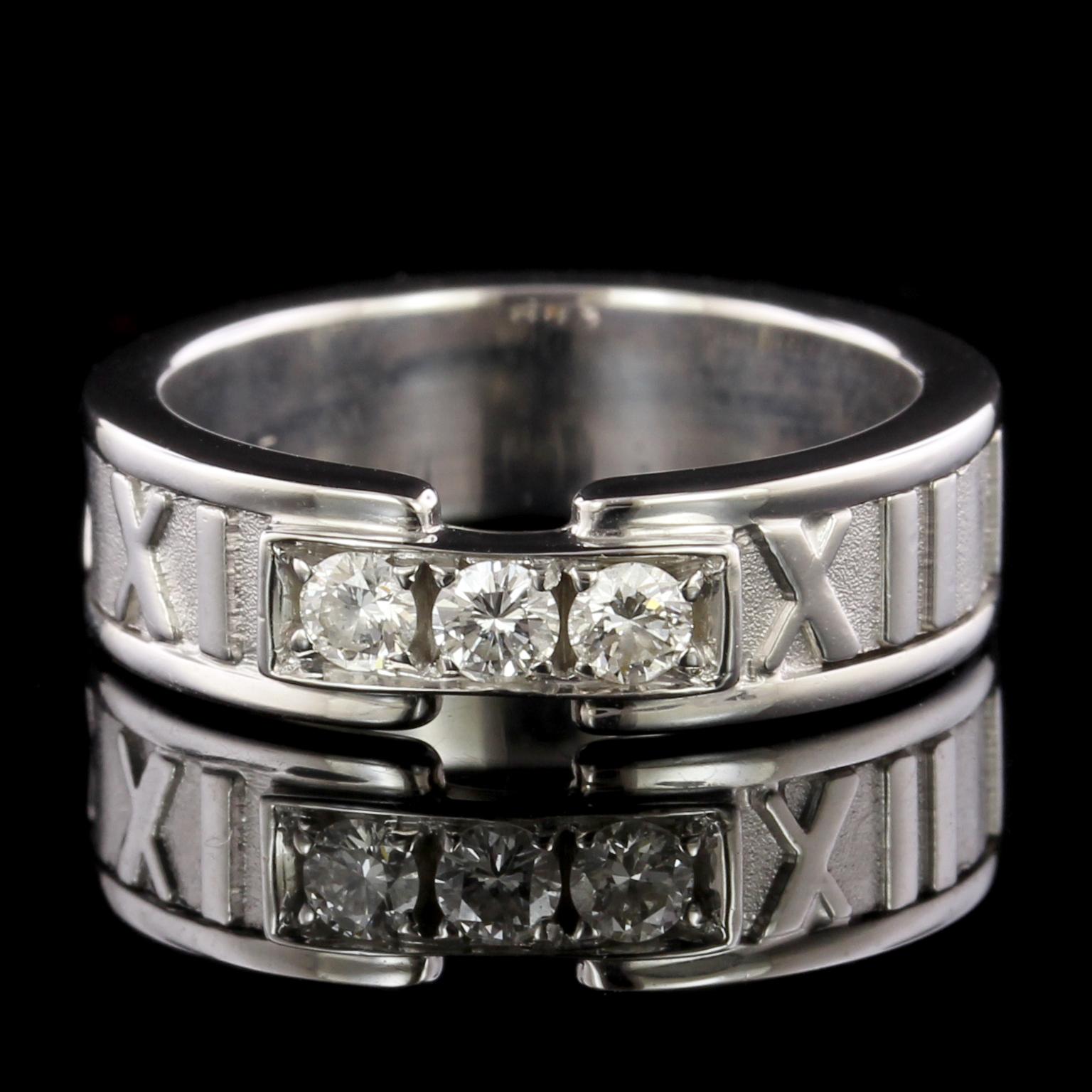 Tiffany & Co. 18K White Gold Diamond Atlas Ring. The ring is set with three full
cut diamonds, approx. total wt. .15cts., F color, VS clarity, size 5, circa 1995, with original
box.