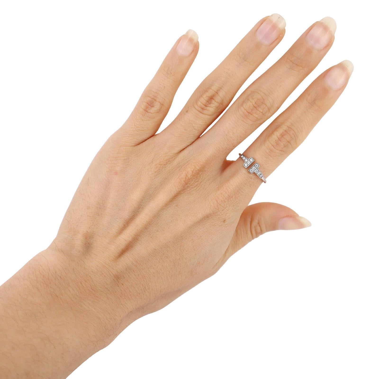 Esta icónica pieza de Tiffany & Co. El anillo T Wire está expertamente elaborado en oro blanco de 18 quilates y elegantemente acentuado con 12 diamantes naturales de talla redonda, que en conjunto pesan aproximadamente 0,24 quilates (color F-G,