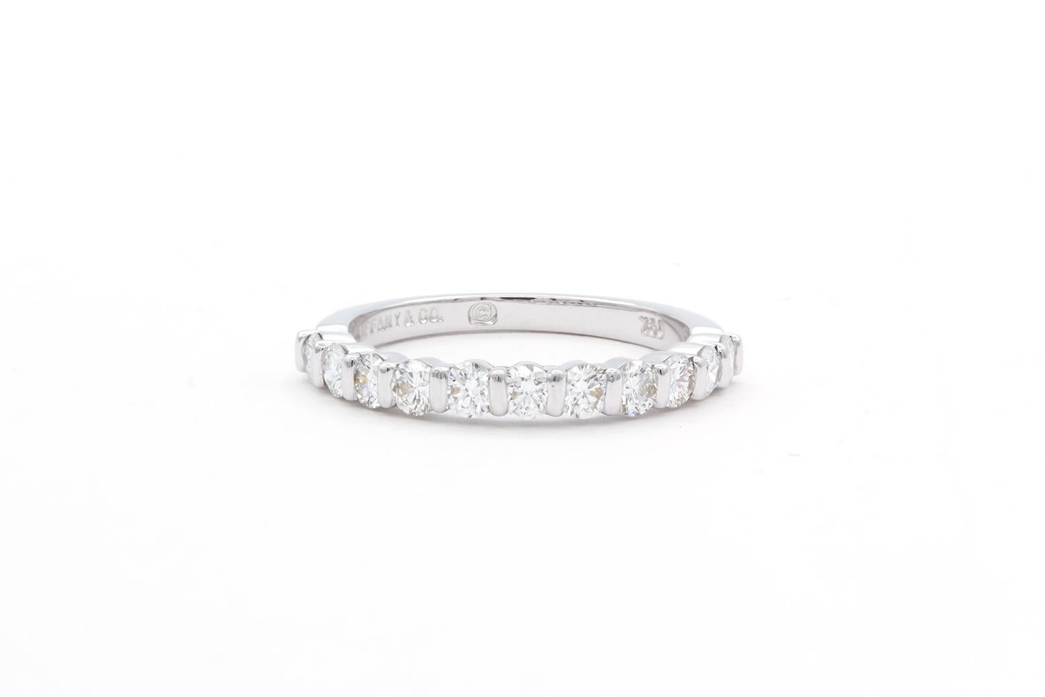 We are pleased to offer this Authentic Tiffany & Co. 18k White Gold & Diamond Tiffany Diamond Wedding Band. It features 0.77ctw F-G/VS1-VS2 Round brilliant Cut Diamonds channel set in 18k white gold extending half way around the ring. It is a size 6