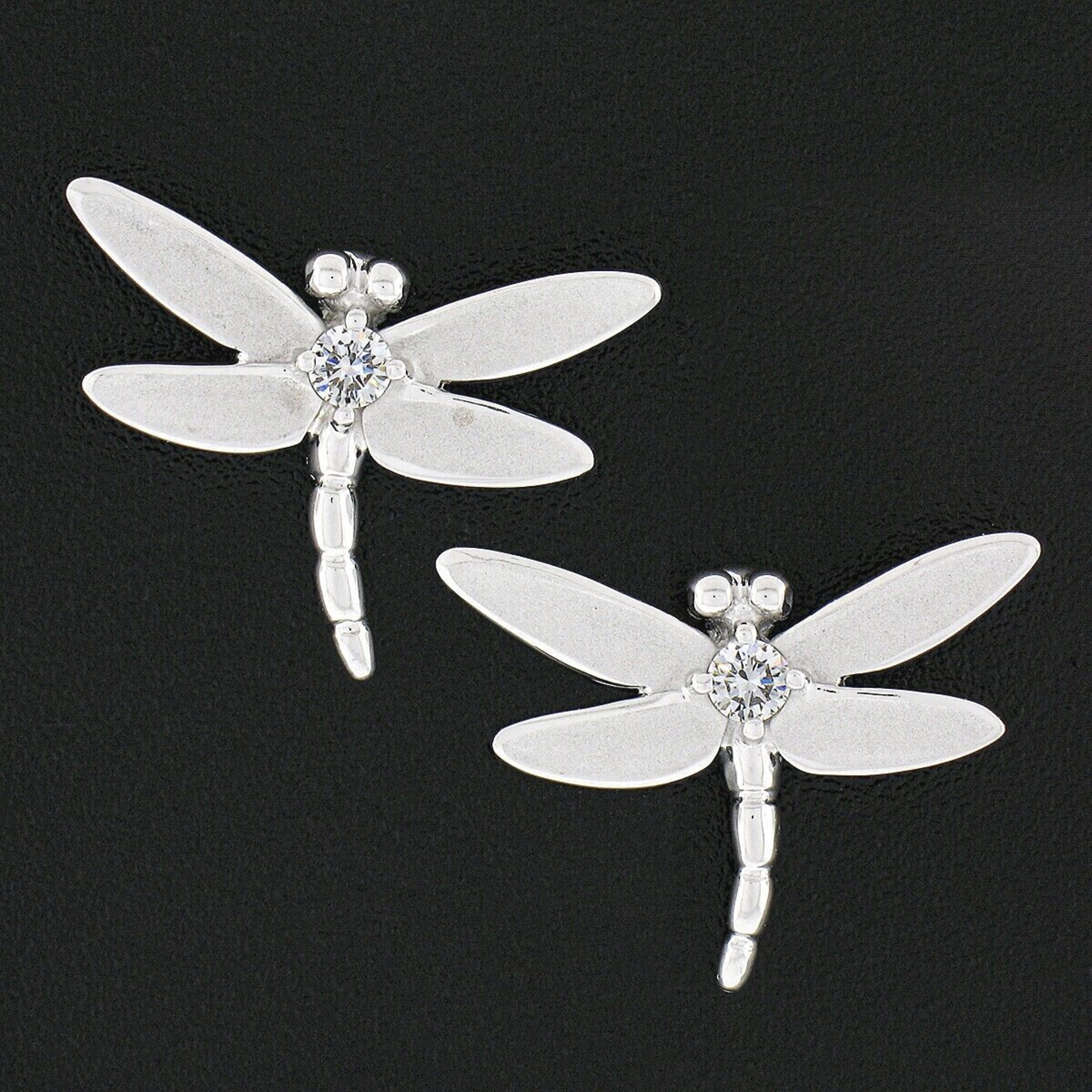 This rare and very lovely pair of Tiffany & Co. earrings was crafted in solid 18k white gold and feature two very well crafted and detailed dragonflies with a very fine quality round brilliant cut diamond at their center. The diamonds total
