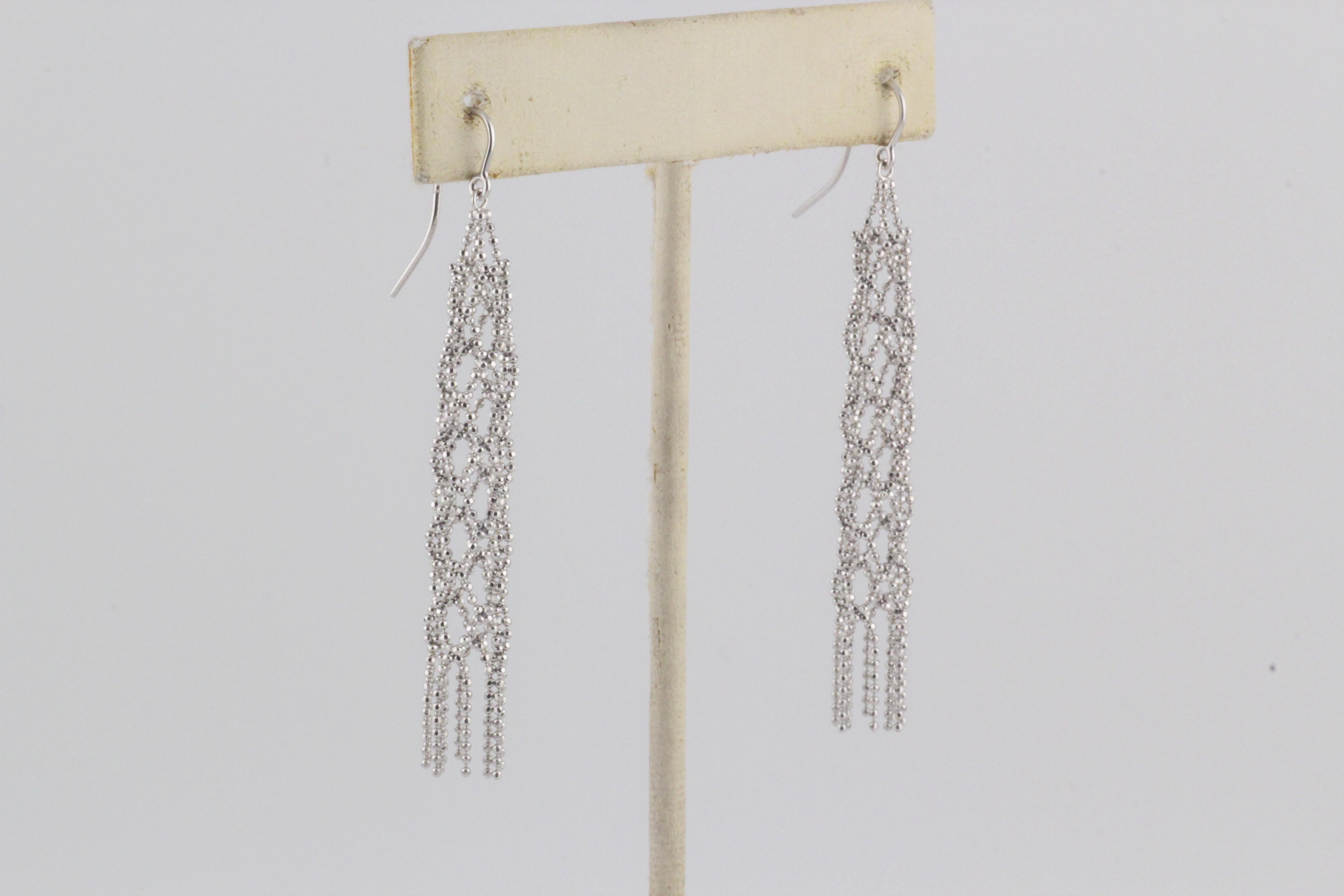 The Tiffany & Co. 18K White Gold Fringe Bead Tassel Drop Dangle Braided Earrings are a stunning embodiment of elegance and modern sophistication. Crafted by the renowned jewelry house Tiffany & Co., these earrings showcase exquisite design and