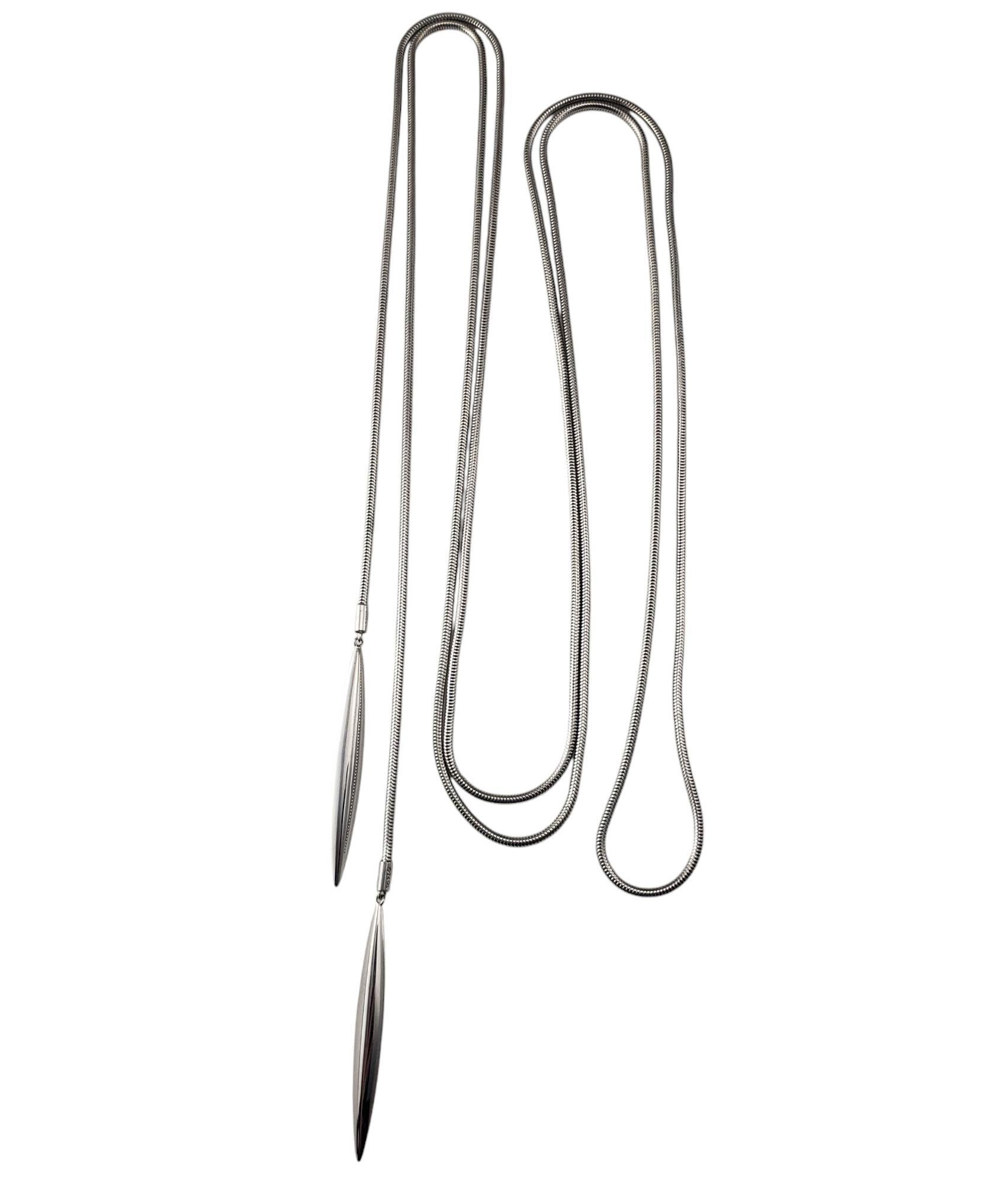 Tiffany & Co. 18K White Gold Long Feather Lariat Necklace-

This sophisticated lariat style necklace features a flexible snake chain design culminating in tow stylized arrow-shaped drop elements. Its versatile design allows it to complement both