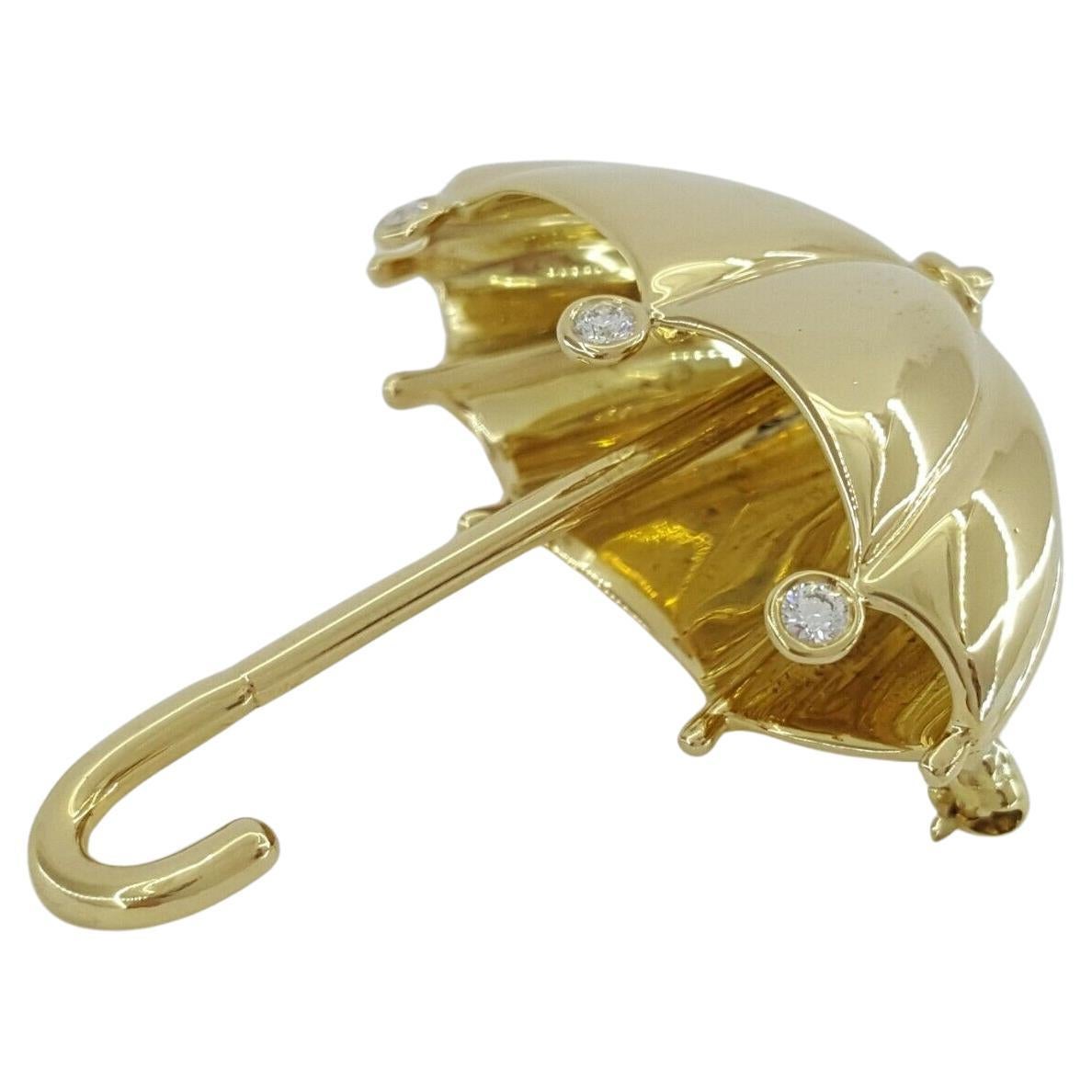Cette broche de Tiffany & Co. est réalisée en or jaune 18 carats et présente un motif de parapluies en diamants de taille ronde de 0,12 carat. D'un poids de 15,1 grammes, il comprend trois diamants ronds de taille brillant d'un poids combiné