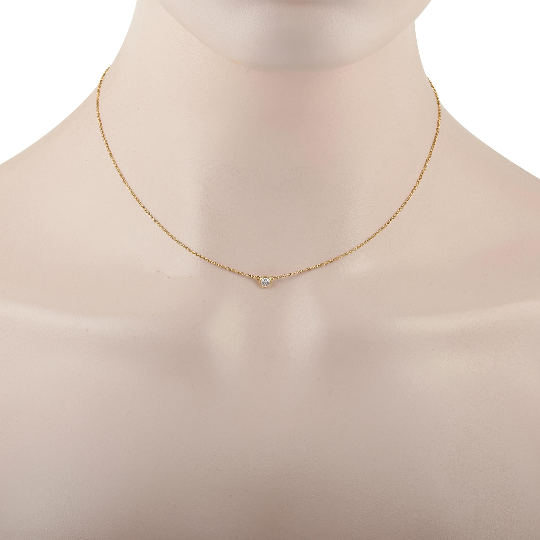 This classic Tiffany & Co. 18K Yellow Gold 0.20 ct Diamond necklace is made with 18K yellow gold and features a solitary 0.20 carat bezel-set diamond pendant. The delicate 18K Yellow Gold Chain measures 15 inches in length and features a spring-ring