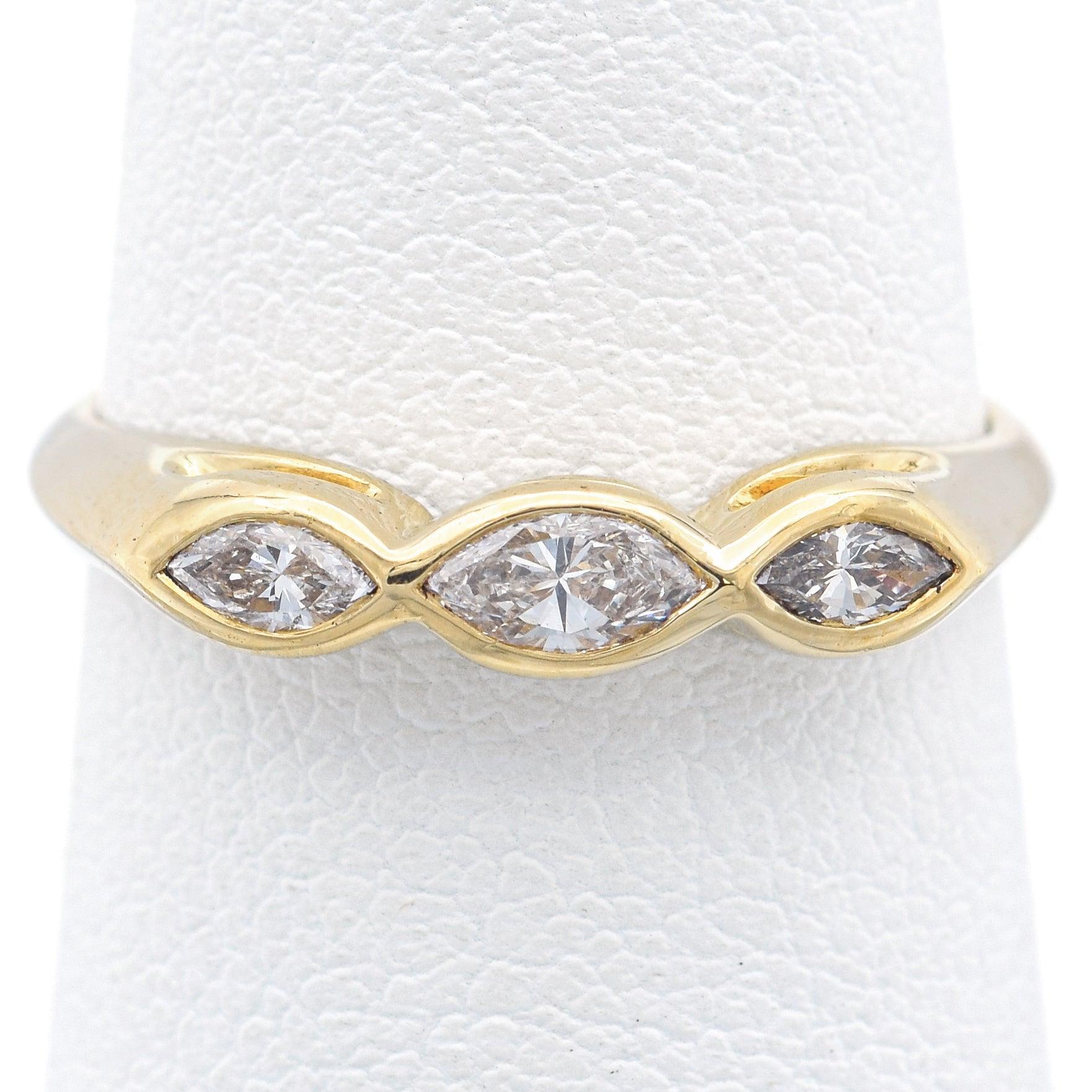 Elegant Tiffany & Co band crafted in 18k yellow gold, set with three marquise-shaped diamonds. The diamonds are flush-set within elongated marquise-shaped frames, creating a refined, flowing design across the band. A timeless and sophisticated