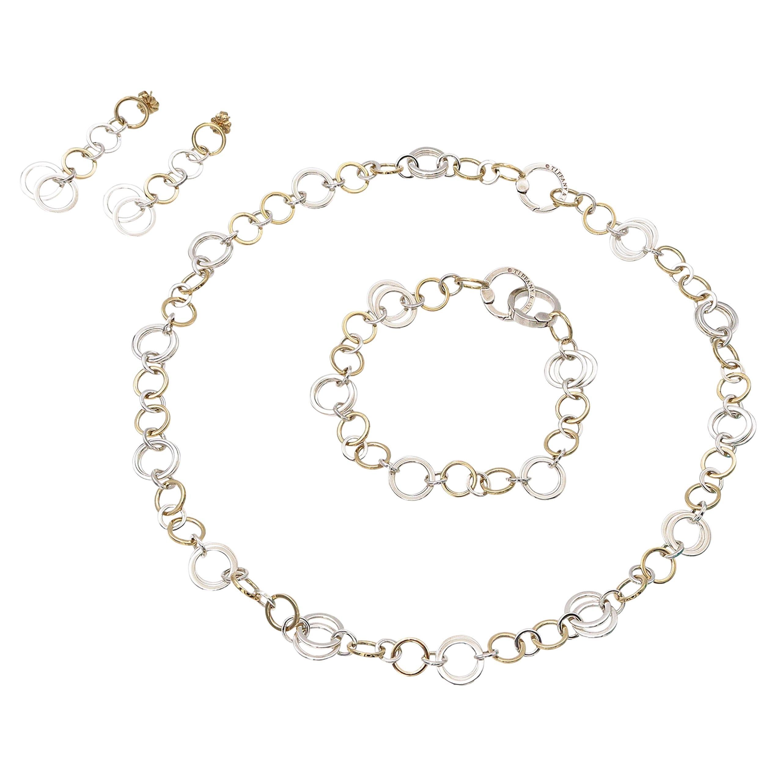 Set di gioielli a cerchio in oro bicolore Tiffany & Co. 18k, che include orecchini, collana e bracciale. Questa splendida parure è realizzata con maglie a cerchio intrecciate in oro giallo e bianco 18 carati, per mostrare il caratteristico