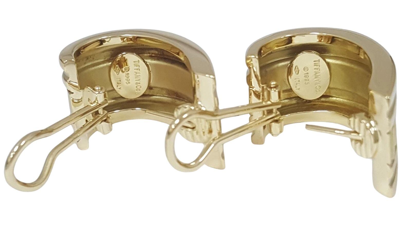 Timeless and bold, these authentic Tiffany & Co. Atlas earrings are crafted in solid 18K yellow gold and date back to 1995. Featuring the iconic Roman numeral motif, the earrings measure approximately 31 x 16 x 3.5 mm and weigh a substantial 25.9
