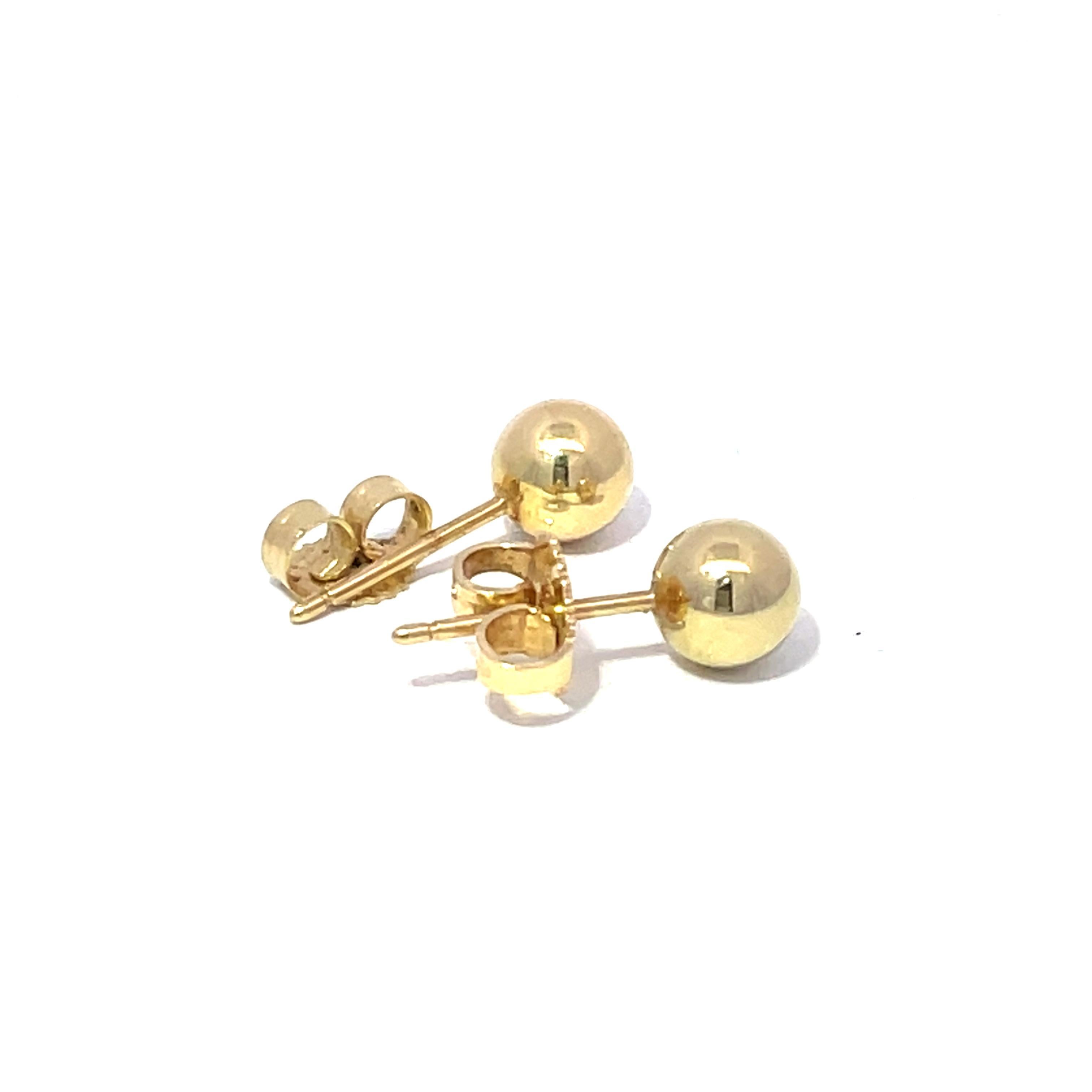 Descubre la refinada sencillez de estos modernos pendientes de Tiffany & Co., elaborados en lujoso oro amarillo de 18 quilates. Cada pendiente presenta una elegante esfera de oro pulido, que emana un cálido tono amarillo que complementa cualquier