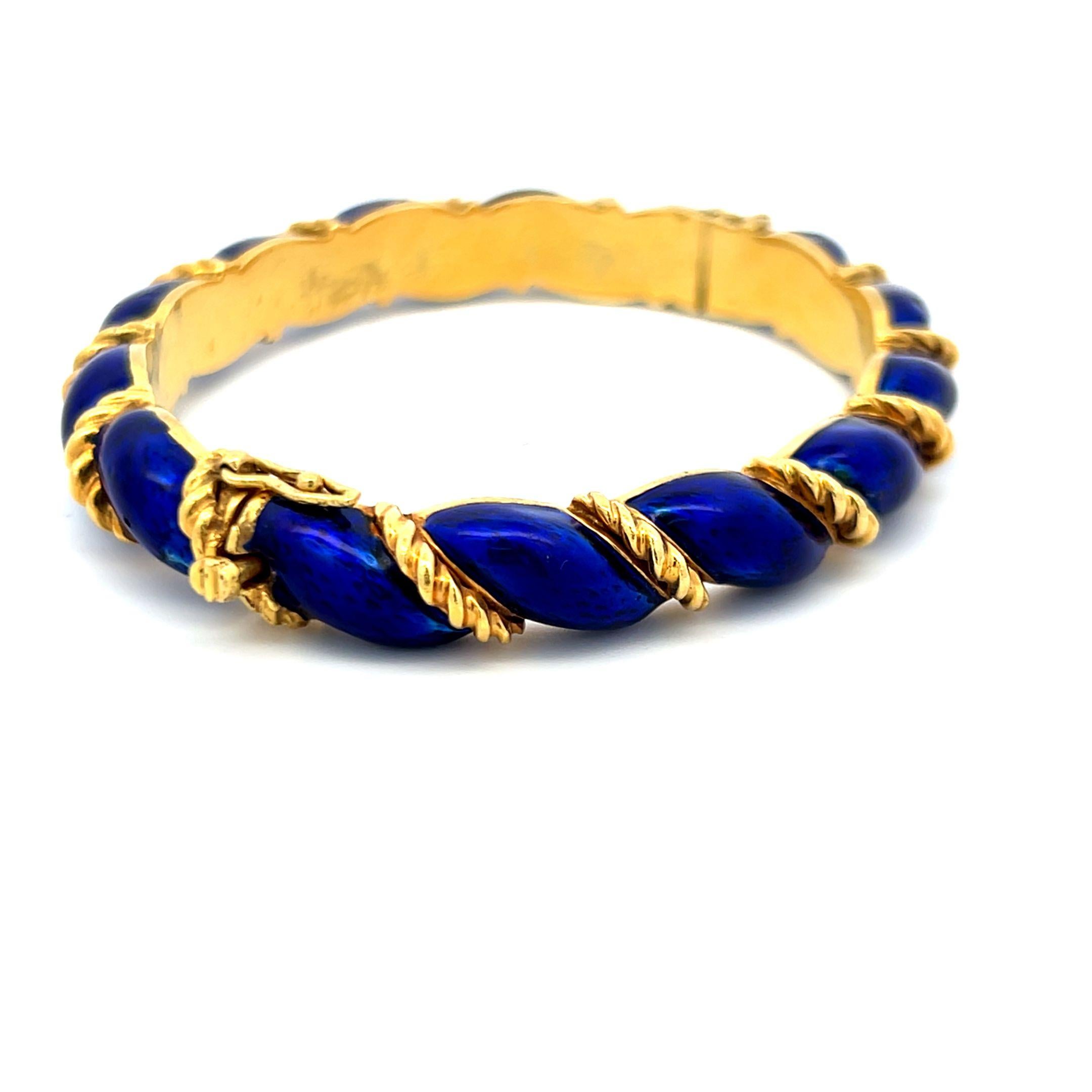 Designer :
Tiffany & Co
Titre :
Ce remarquable bracelet Tiffany & Co. présente des panneaux d'émail bleu cobalt profond enveloppés dans de l'or jaune 18 carats torsadé, créant un design en spirale audacieux et élégant. L'artisanat met en valeur le