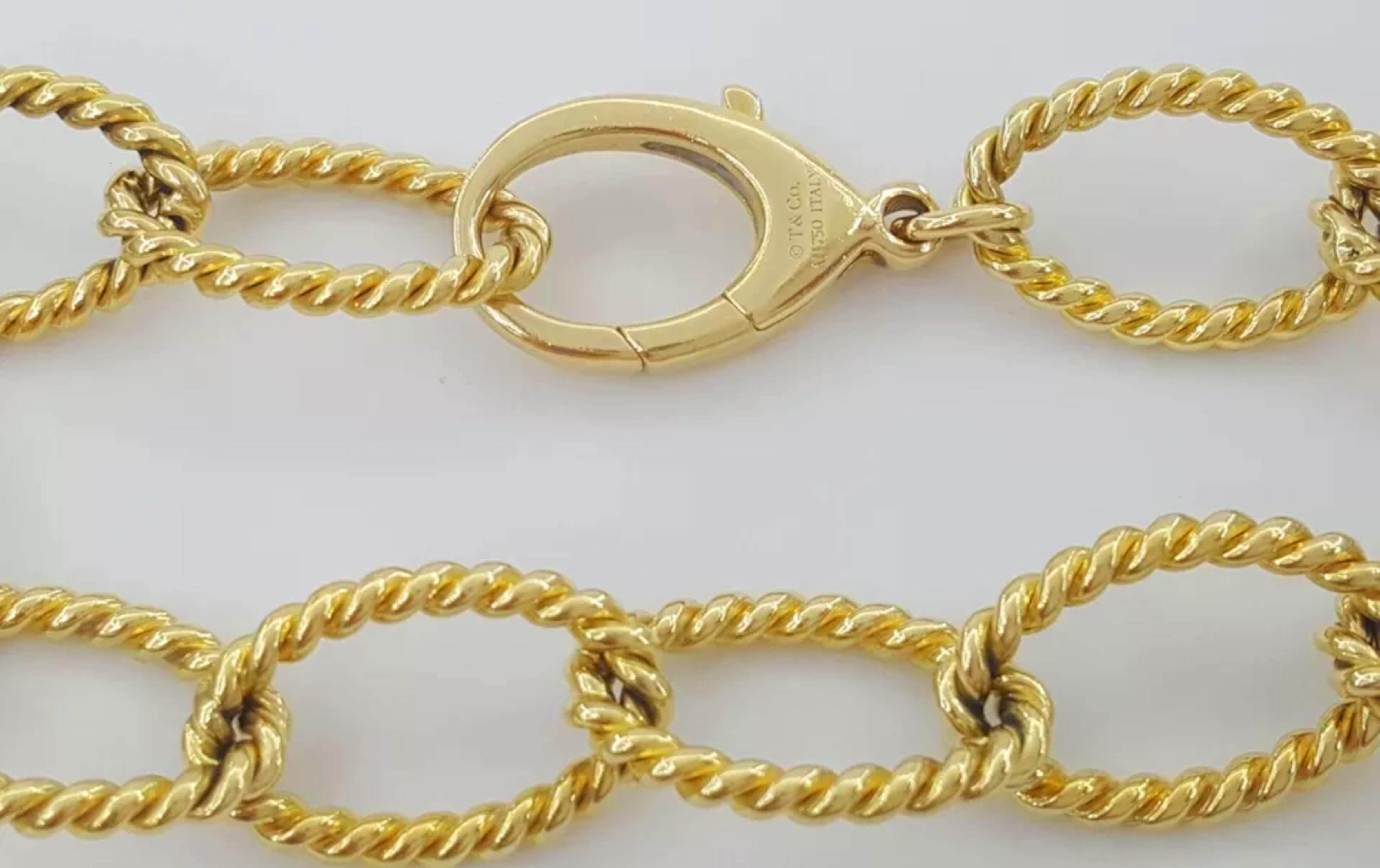 Tiffany & Co. 18k Yellow Gold Braided Oval Link Bracelet. The bracelet weighs 28.8 grams, is 8.5 inches long, and has dimensions of 19.5 mm x 12 mm (length x width) with a thickness of 2.3 mm. It features the stamp 