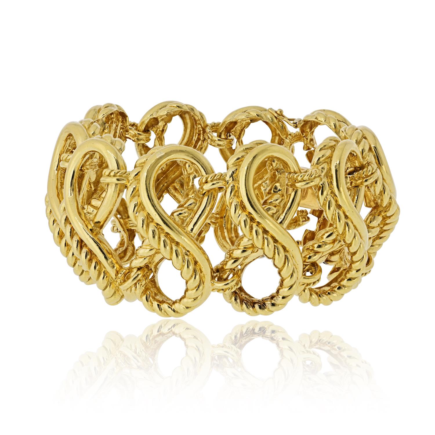 Un sorprendente bracciale vintage in oro 18 carati di Tiffany & Co., caratterizzato da un audace design a gabbia traforata composto da scultoree maglie convesse a forma di otto. Questo pezzo impressionante è composto da dieci maglie splendidamente