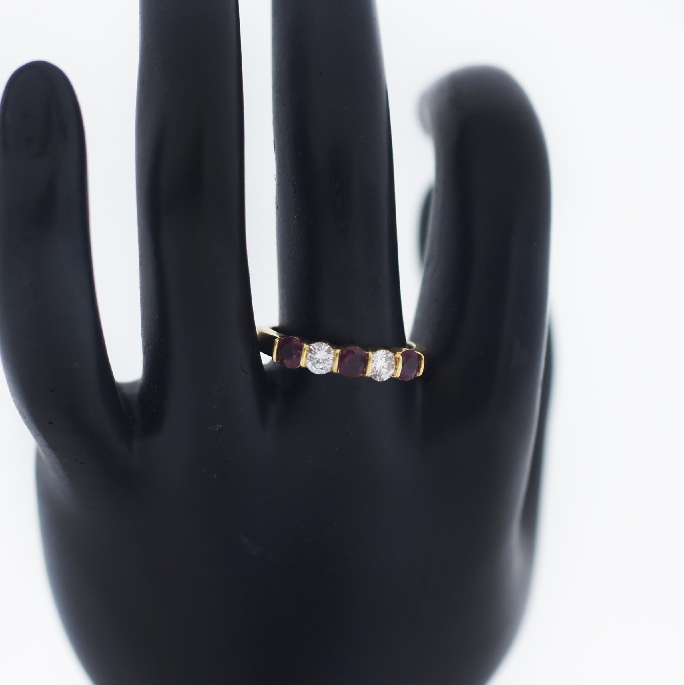 Beautiful and simple 18k yellow gold diamond and ruby ring by Tiffany and Co. The ring is set with three round rubies totalling approximately 0.18ct in a four claw setting which each disperse a bright pinky/red hue throughout. Alternating between