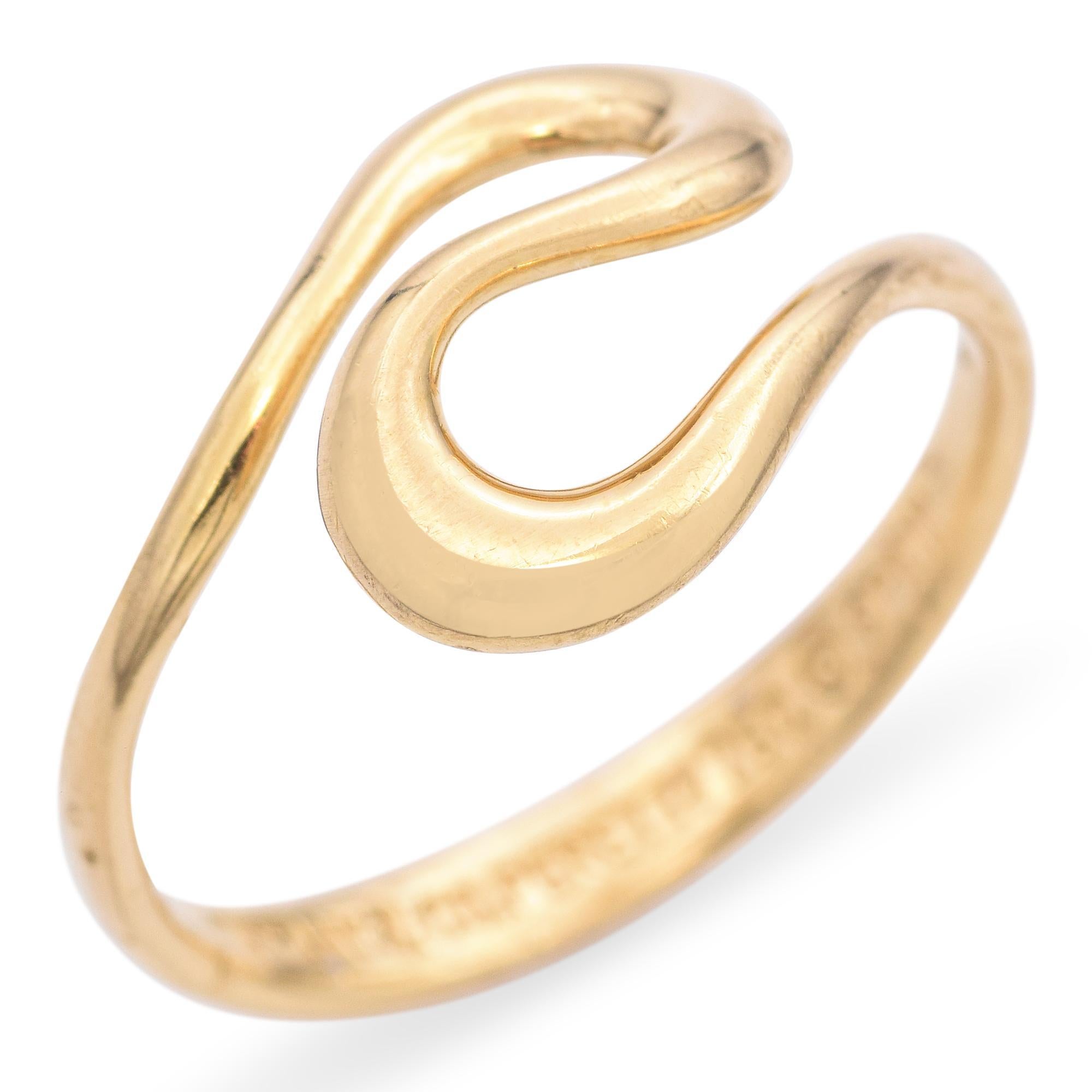 A striking ring designed by Elsa Peretti for Tiffany & Co. from the late 20th century. Crafted in 18k yellow gold, this elegant piece features a fluid, open-ended design that gracefully wraps around the finger. The smooth, polished surface enhances