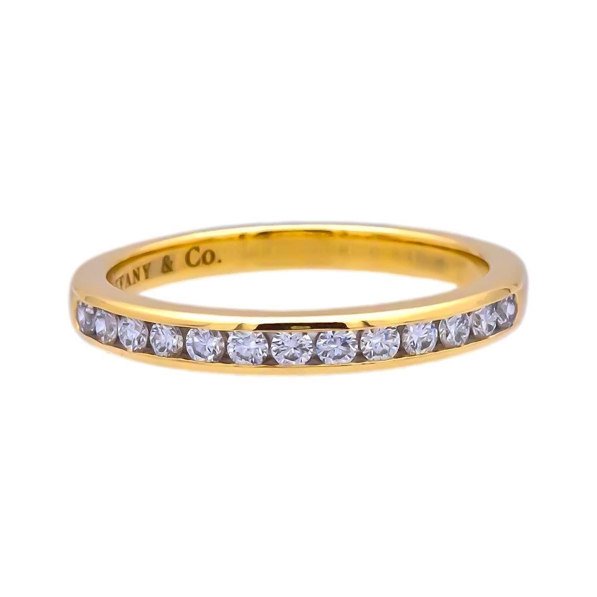 Tiffany & Co. wedding/anniversary band finely crafted in 18 karat yellow gold with 15 channel set round brilliant cut diamonds weighing 0.24 carats total. Fully Hallmarked with logo and metal content.

Ring Specifications
Brand: Tiffany & Co.
Style;