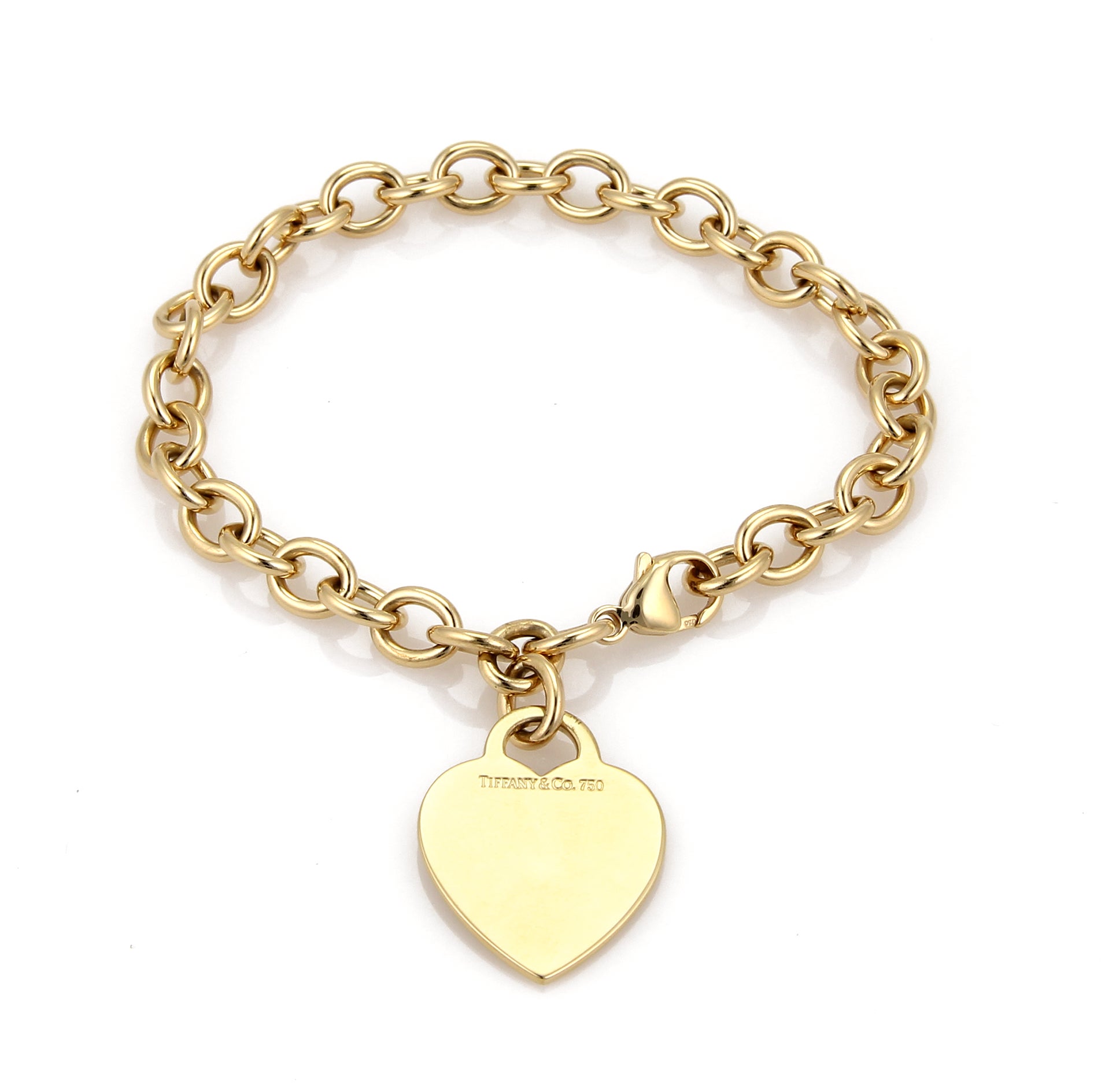 An elite authentic bracelet from Tiffany & Co., forged from solid 18k yellow gold with a fine polished finish, it features a sturdy oval chain link bracelet with a solid heart tag charm. The bracelet has a large lobster clasp and it has full