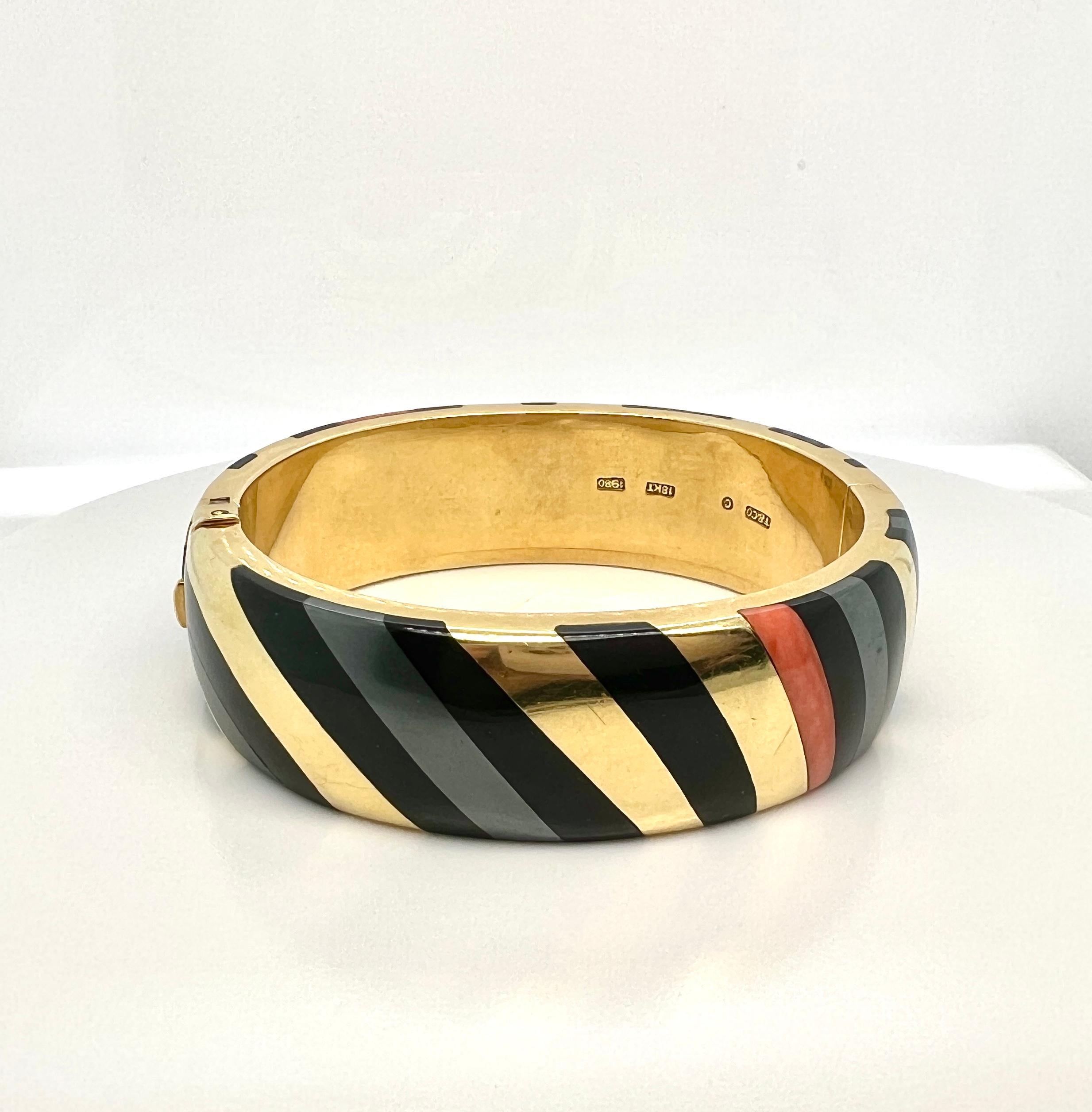 Tiffany & Co. 18k Yellow Gold Inlay Bangle Bracelet.

Details:
Inlaid black jade, hematite and coral plaques. 
18k yellow gold.
1980.
Signed T&Co, C, 1980.

Total Weight: 72.8 grams

In excellent condition.