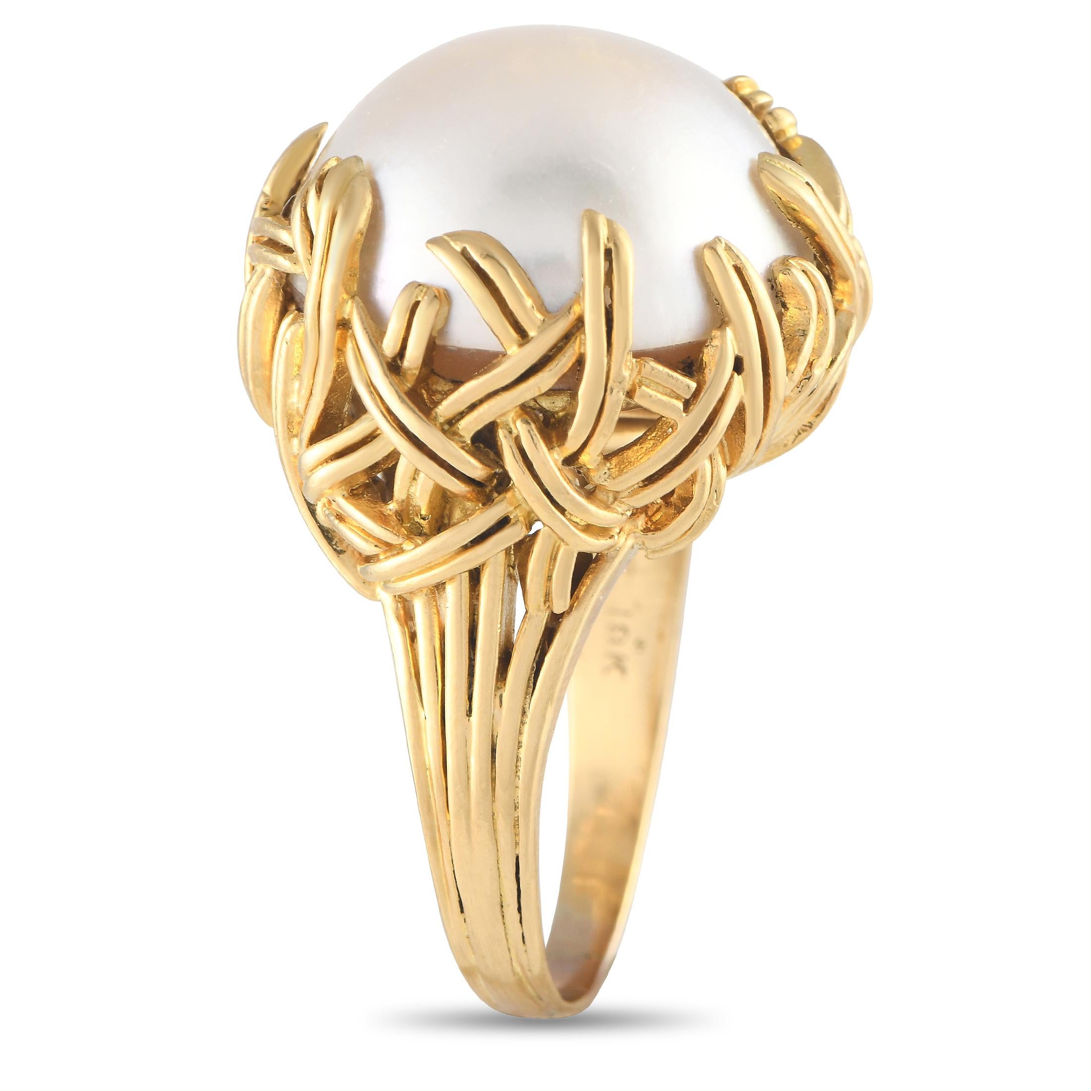 A gorgeous heirloom piece. This Tiffany & Co. ring intrigues with its beautiful mab pearl cradled by a stylized woven basket in 18K yellow gold. The ring's top dimensions measure 17mm by 19mm. Offered in estate condition, this signed Tiffany & Co.