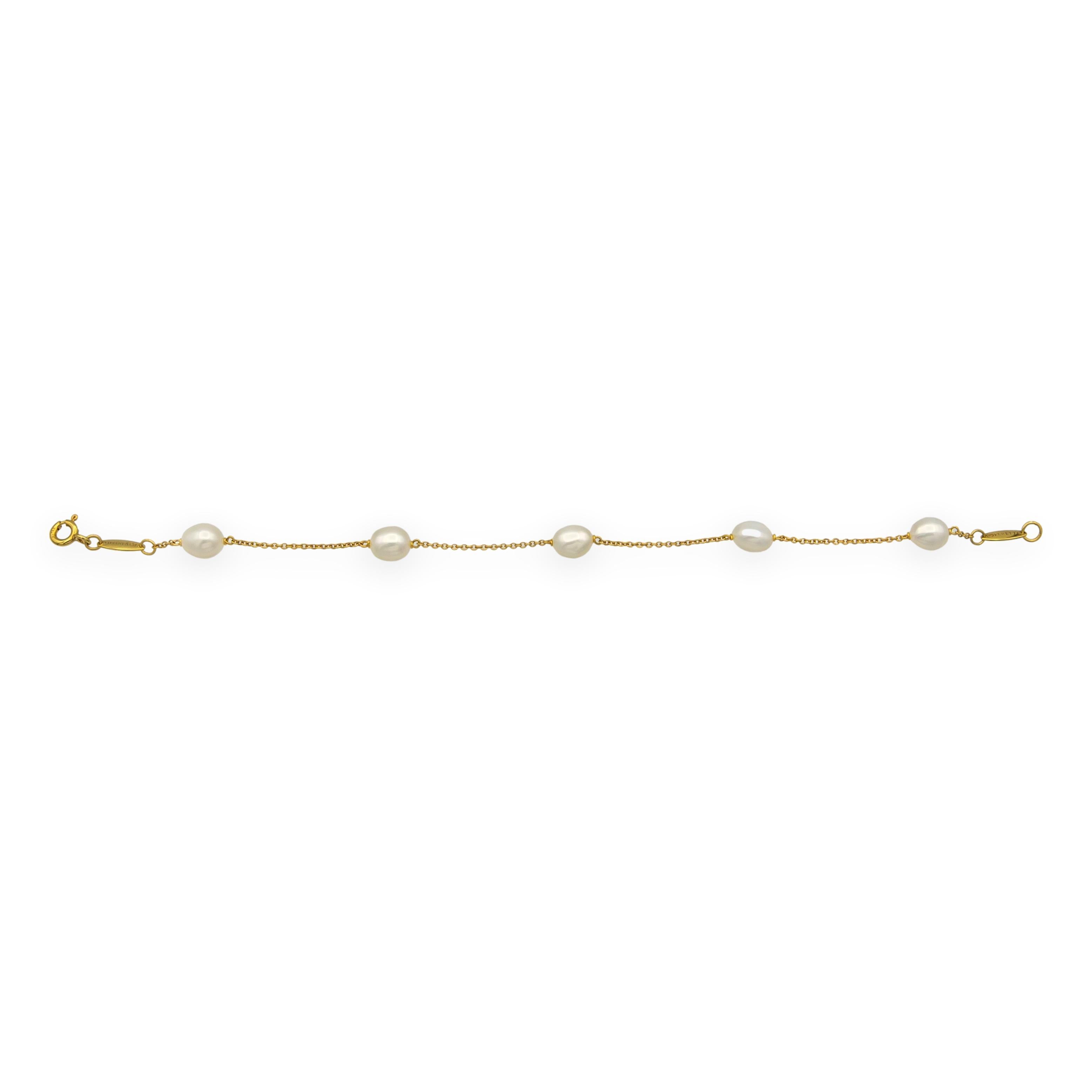 Pulsera Tiffany & Co. de segunda mano de la colección Elsa Peretti con cinco perlas cultivadas de agua dulce espaciadas uniformemente a lo largo de una fina cadena de cable de oro amarillo de 18 quilates. Sellos de calidad estampados en ambas