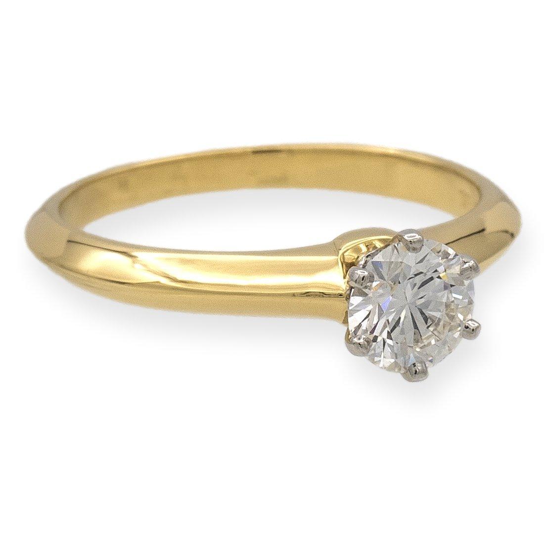 Tiffany & Co. classic solitaire engagement ring finely crafted in 18 karat yellow gold featuring a round brilliant diamond center weighing .47 cts H color , Fine VS2 clarity set in a platinum 6 prong basket setting. Fully hallmarked with logo and