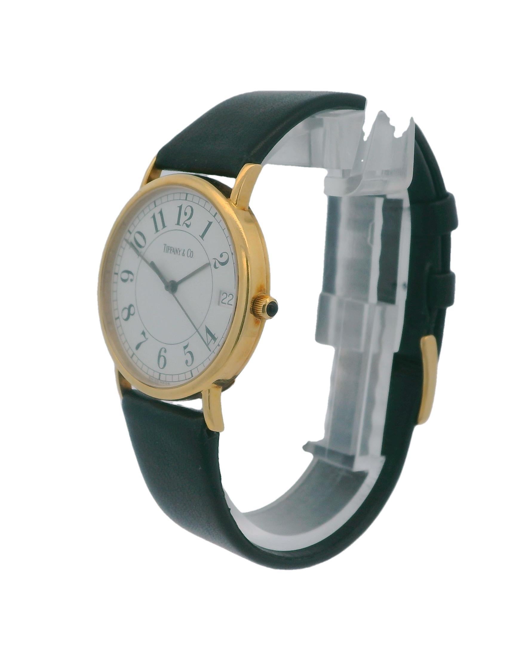 Crafted in the 21st century, this Tiffany & Co. watch features a classic round shape with a precise quartz movement. The white dial is adorned with bold Roman numerals, offering a timeless elegance. Encased in 18k gold, the watch exudes luxury and