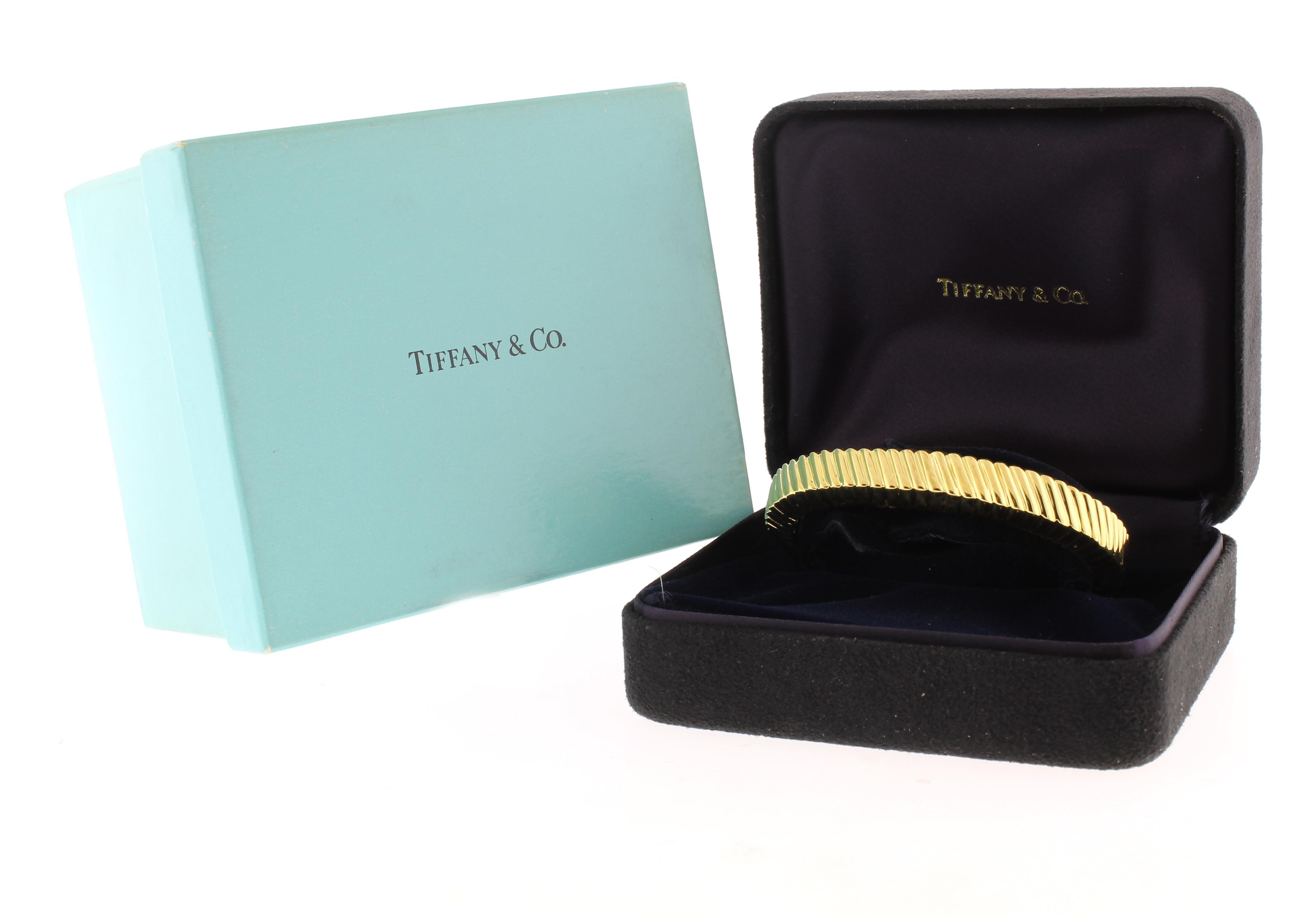 This cuff bracelet crafted by Tiffany & Co. is stamped 1998 as the year it was made.
♦ Designer: Tiffany & Co.
♦ Metal: 18 Karat Yellow Gold
♦ Circa: 1998
♦ Inner Diameter: 2 1/4 inches
♦ Size: fits a 6 to 6 1/4 inch wrist
♦ Width: 1/2 inch
♦ 