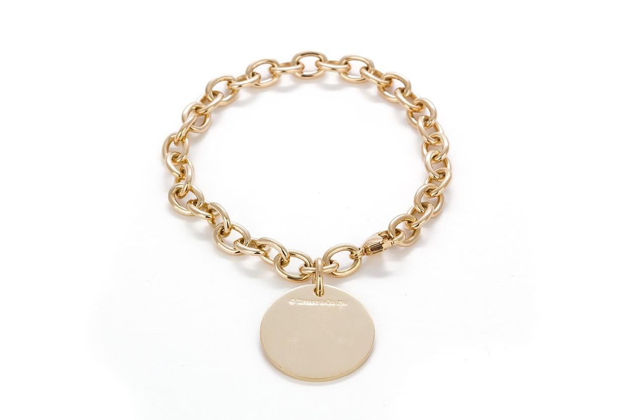 We are pleased to offer this Tiffany & Co. 18k Yellow Gold Round Charm Bracelet. In classic Tiffany style this bracelet is crafted from 18k yellow gold and features a round charm. Streamlined and modern, this bracelet shines with sophistication and
