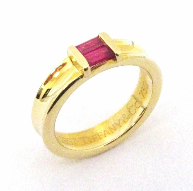  TIFFANY & Co. 18K Gold Ruby Stacking Ring 4 

Metal: 18K yellow gold
Size: 4
Band Width: 4.5mm
Ruby: two emerald cut rubies, carat total weight .30
Hallmark: ©1997 TIFFANY&Co. 750 
Condition: Excellent condition, like new

Limited edition, no