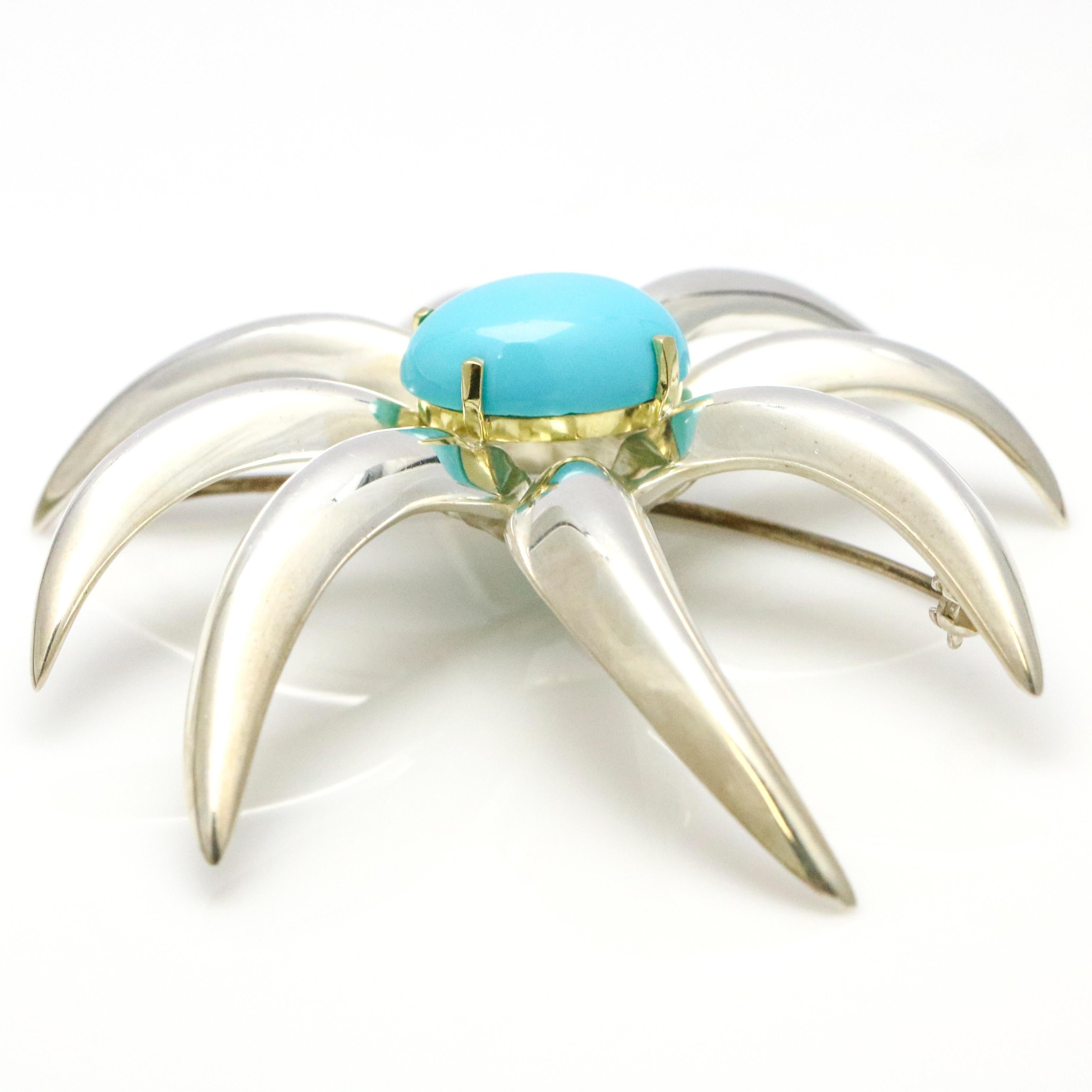 1995 Tiffany & Co. Fireworks Brooch in sterling silver and 18 karat yellow gold. The pin has a cabochon Persian turquoise gemstone center. Turquoise, 16mm x 12mm.