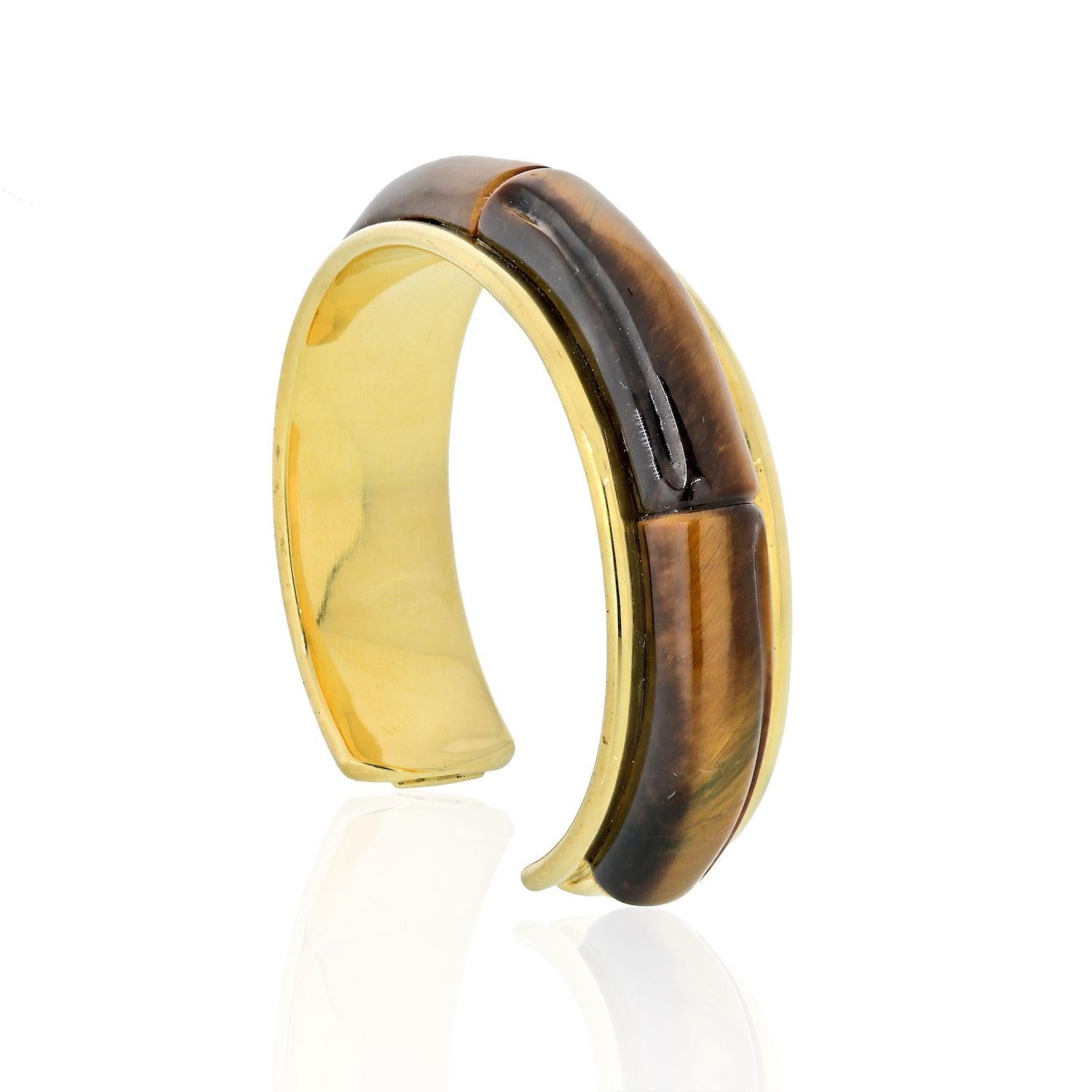 Tiffany & Co 18K yellow gold cuff bracelet set with four tiger's-eye panels. 
SIZE/DIMENSIONS: 15.5 cm (continuous inner circumference), 1.5 cm width
GROSS WEIGHT: 65.0 grams
METAL: 18k yellow gold
STONES: 4 carved tiger's-eye quartz