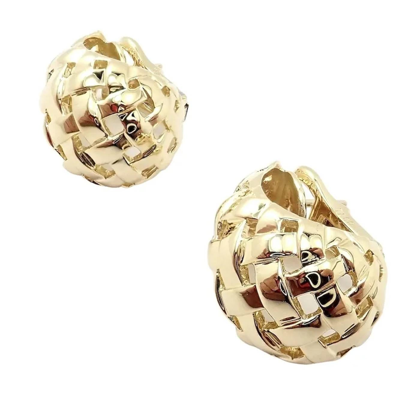 A pair of Tiffany and Company 18 karat yellow gold Vannerie basket weave clip-on hoop earrings. These earrings feature an open basketweave motif in a J hoop design with clip-on closures. This Tiffany & Co. basket weave earrings weigh approx. 17.4