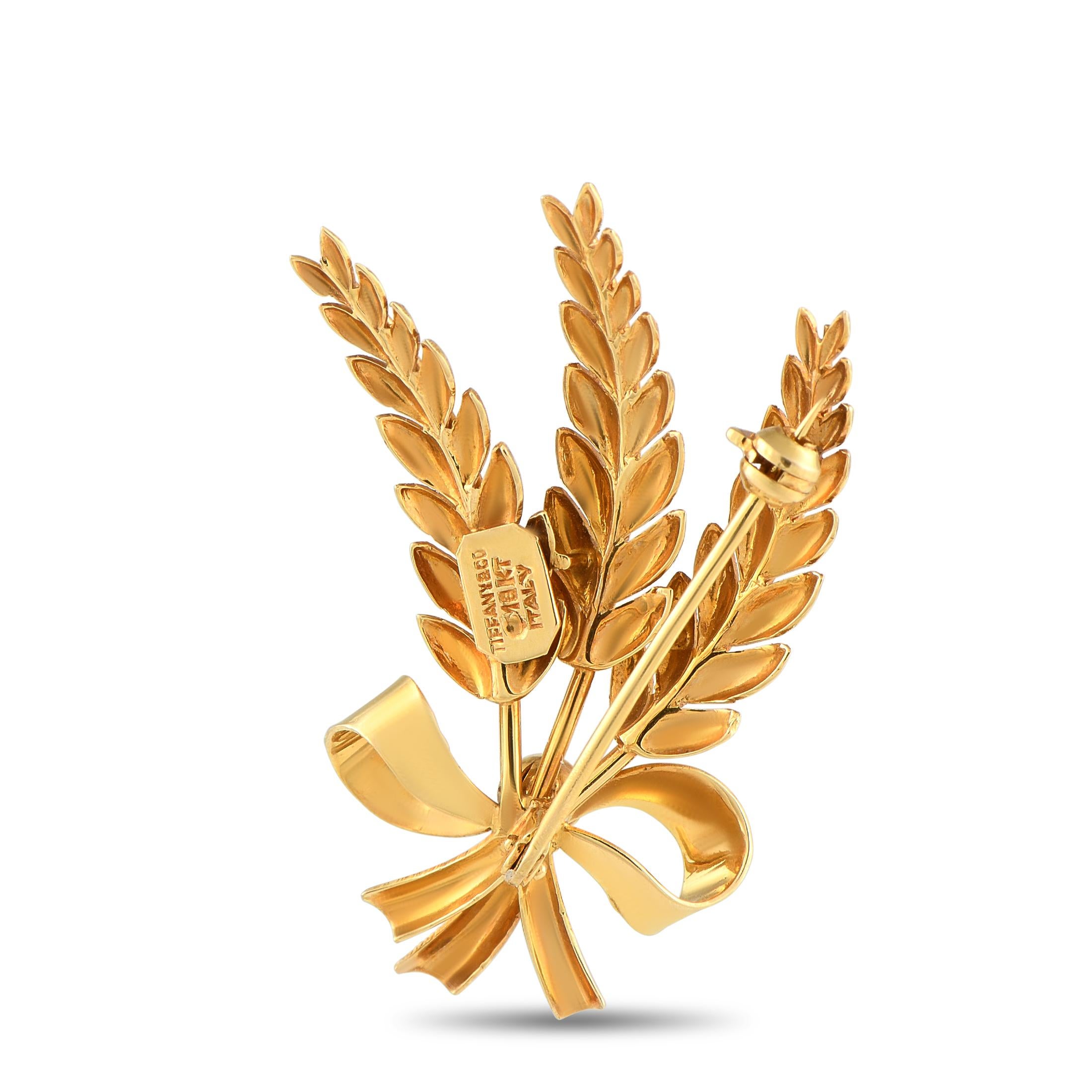 A mid-century Tiffany & Co. creation, crafted in solid 18K yellow gold. This brooch features a bunch of textured wheat stalks held by a polished bow. Signed and stamped Tiffany & Co 18KT Italy, this vintage piece is bound to bring a layer of